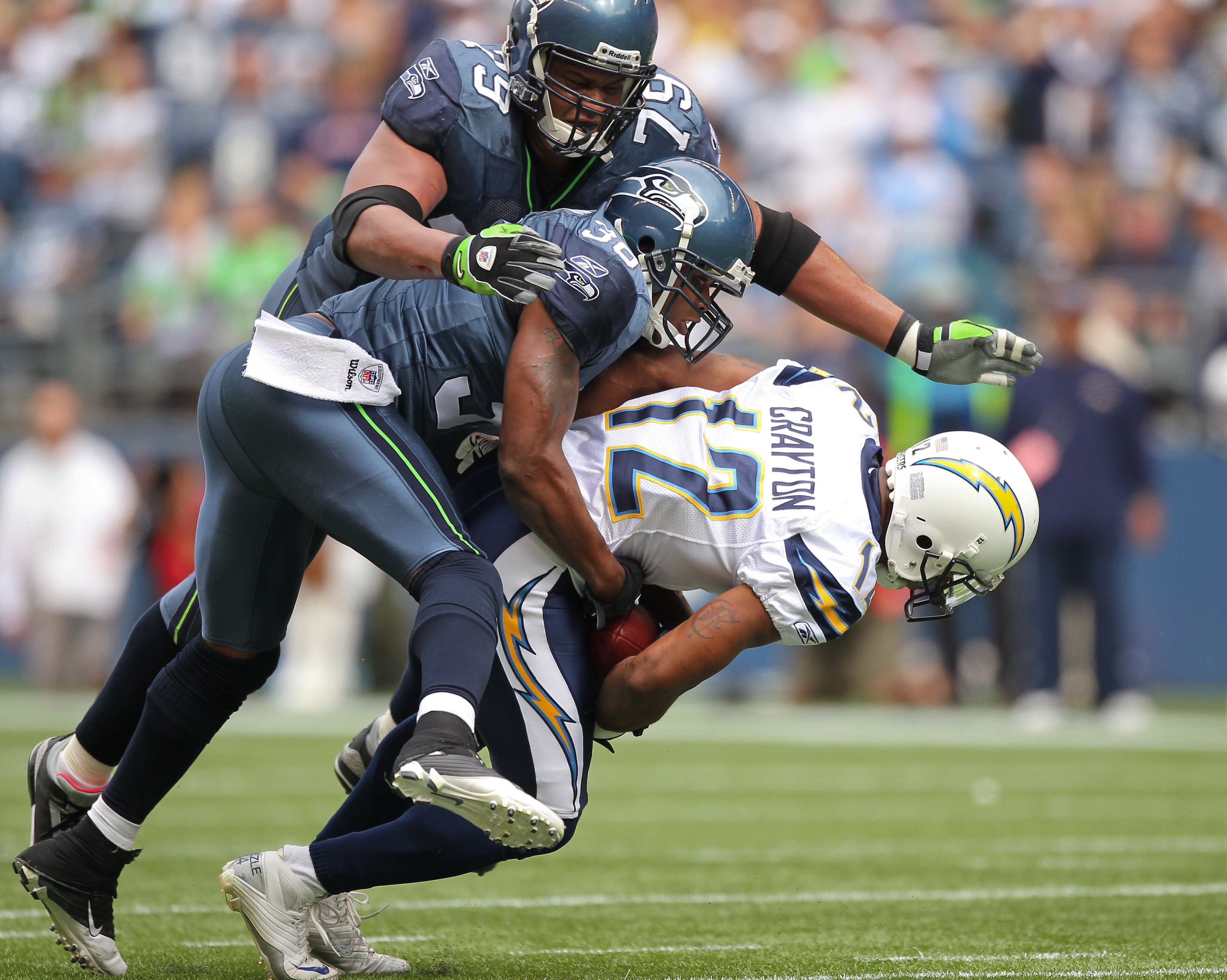 SEATTLE - SEPTEMBER 26:  Wide receiver Patrick Crayton #12 of the San Diego Chargers is tackled by Lawyer Milloy #36 and Red Bryant #79 of the Seattle Seahawks at Qwest Field on September 26, 2010 in Seattle, Washington. (Photo by Otto Greule Jr/Getty Ima
