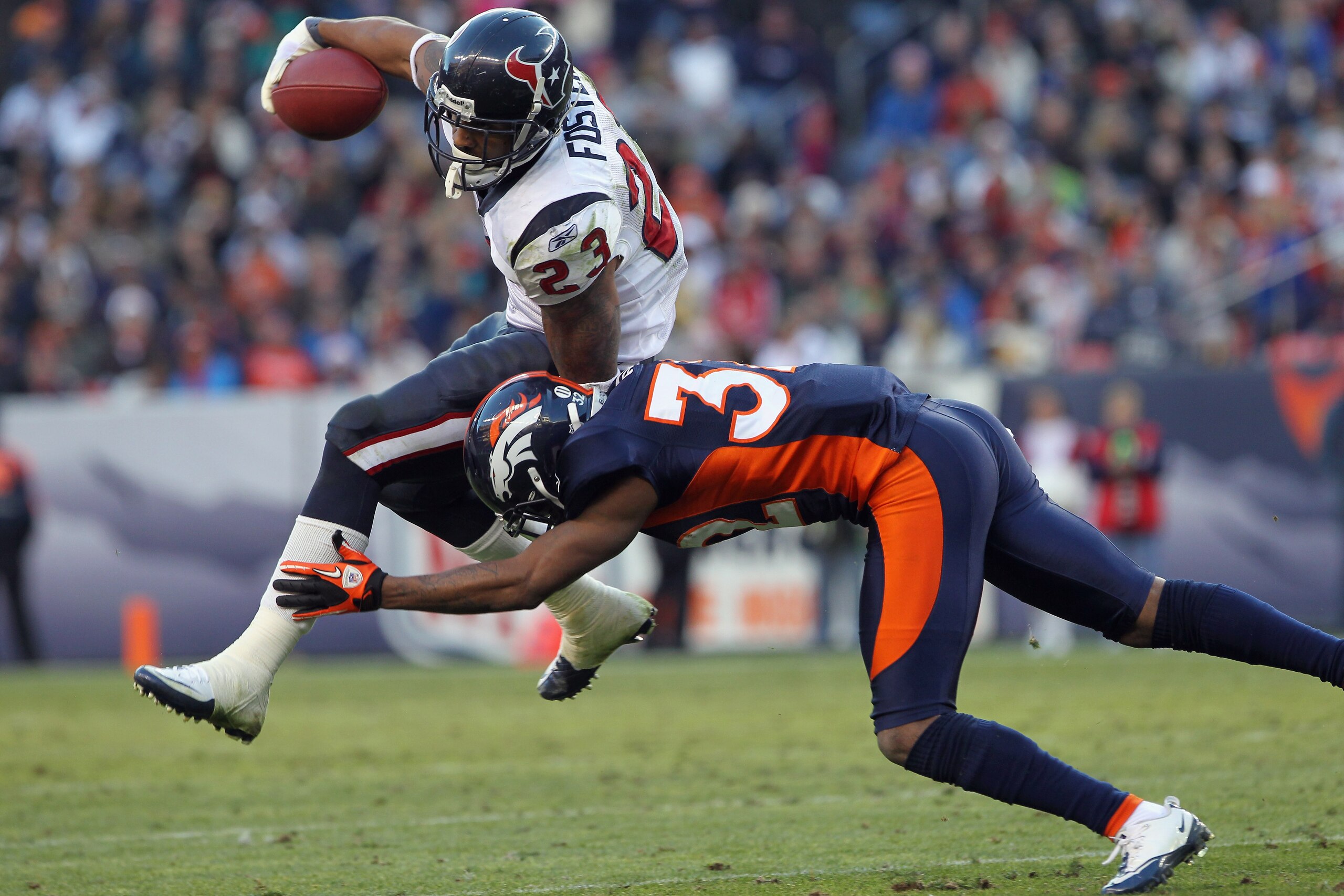 DENVER - DECEMBER 26:  Running back Arian Foster #23 of the Houston Texas rushes with the ball and is tackled by cornerback Perrish Cox #32 of the Denver Broncos at INVESCO Field at Mile High on December 26, 2010 in Denver, Colorado. The Broncos defeated