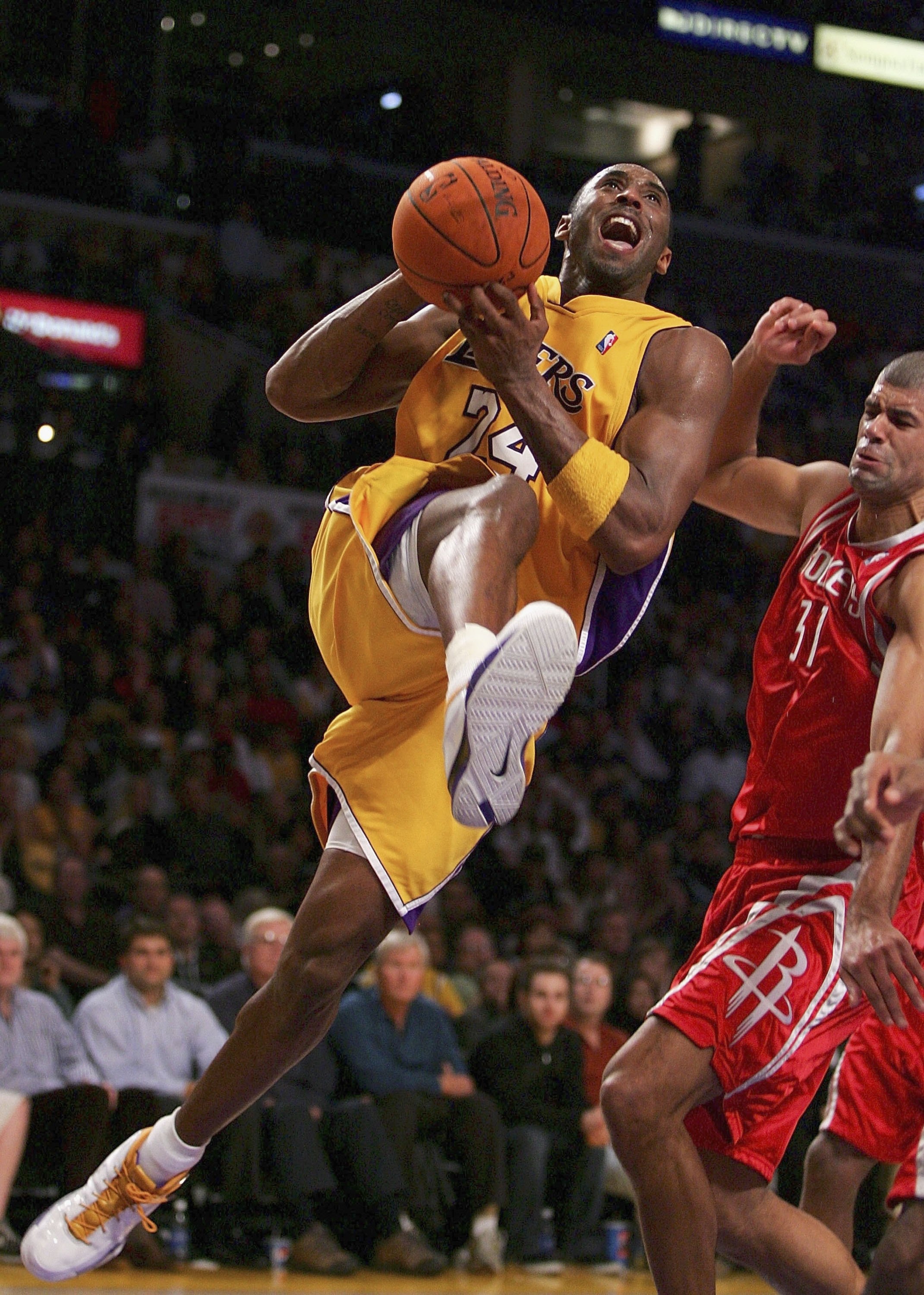 LOS ANGELES, CA - DECEMBER 15:  Kobe Bryant #24 of the Los Angeles Lakers rushes to the basket as Chris Mihm #31 of the Houston Rockets tries to stop him during the second half of the game at the Staples Center on December 15, 2006 in Los Angeles, Califor