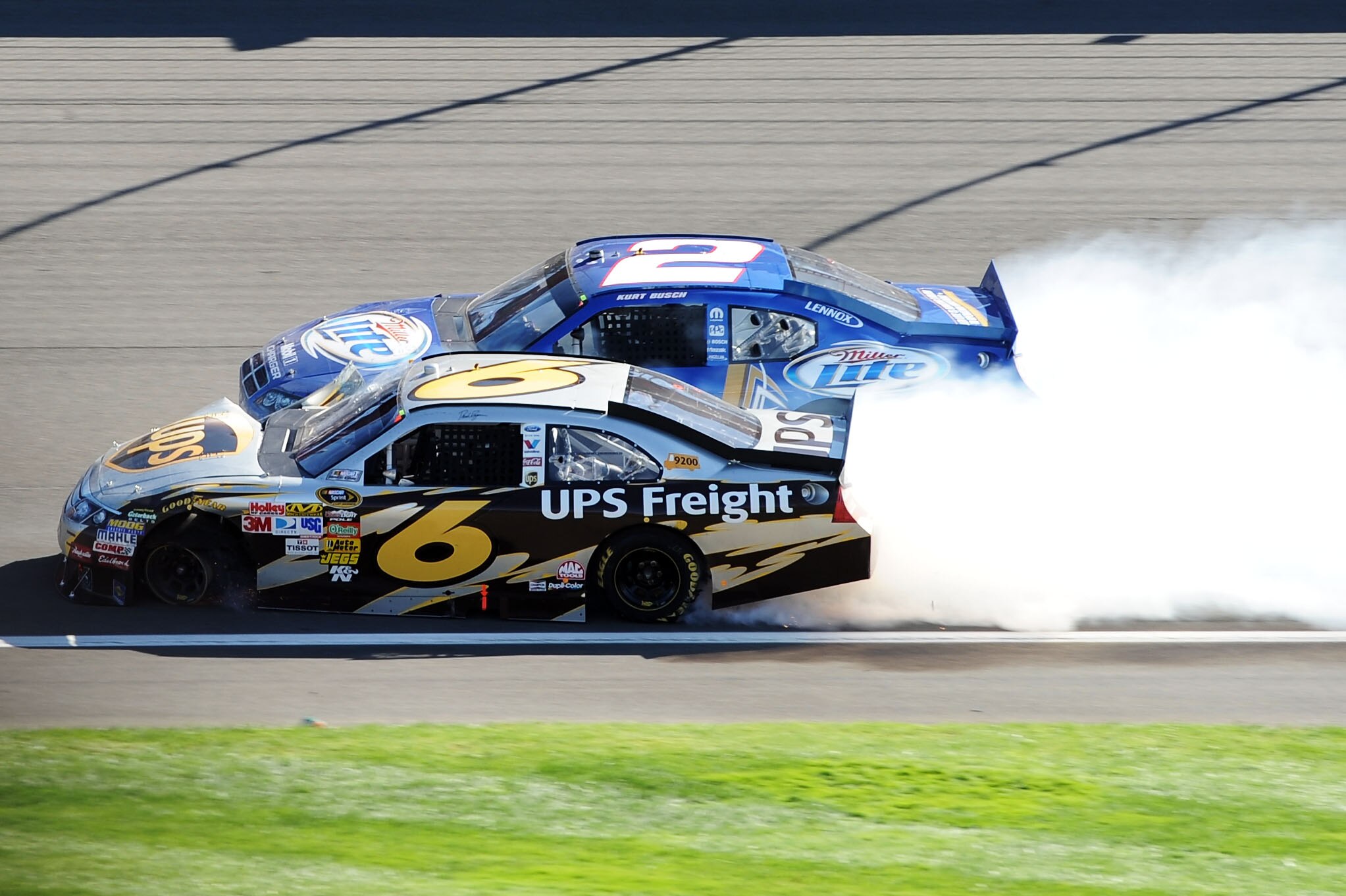 FONTANA, CA - OCTOBER 10:  David Ragan, driver of the #6 UPS Ford, and Kurt Busch, driver of the #2 Miller Lite Dodge, crash in to each other during the NASCAR Sprint Cup Series Pepsi Max 400 on October 10, 2010 in Fontana, California.  (Photo by Harry Ho