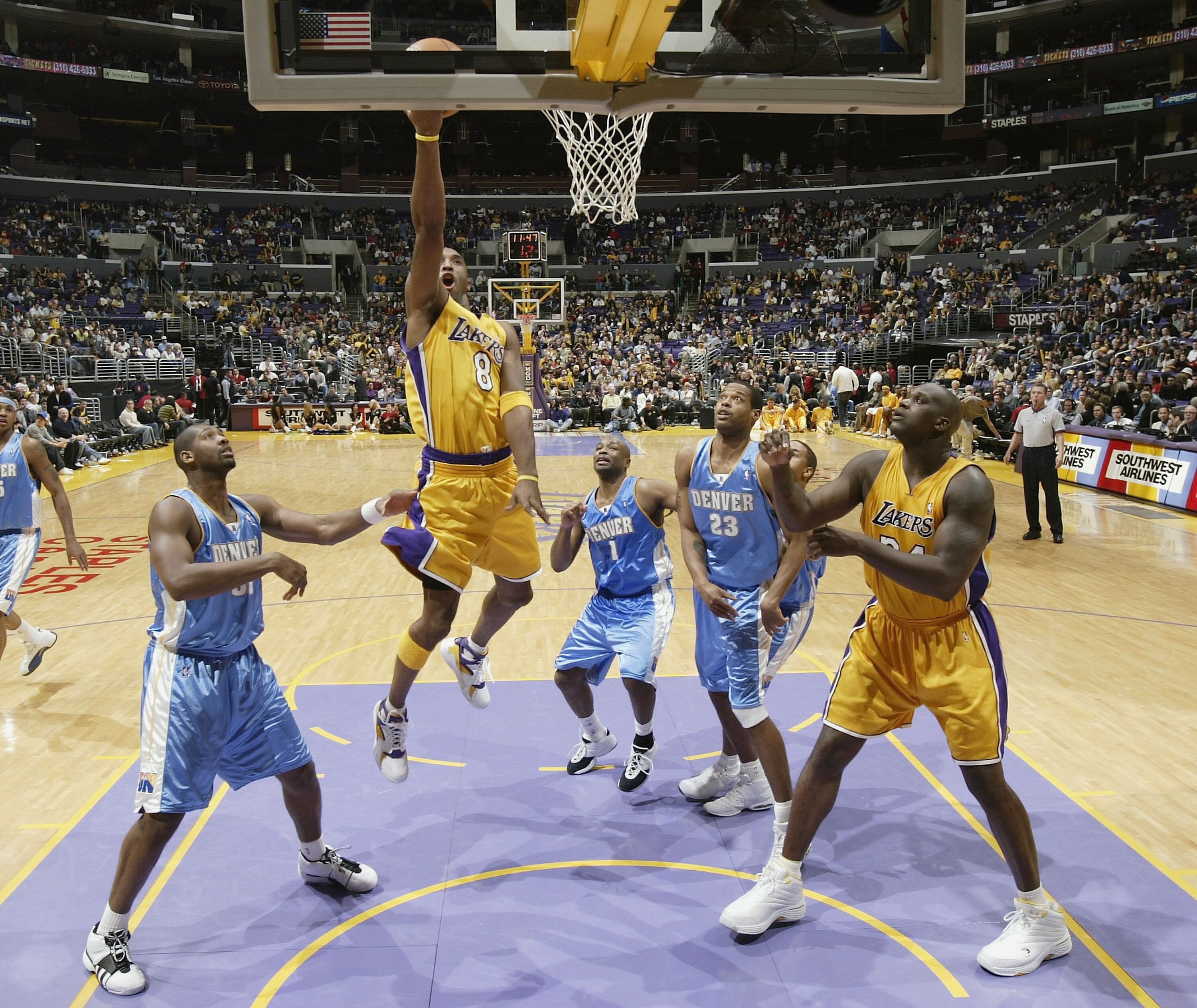 LOS ANGELES - DECEMBER 19:  Kobe Brayant #8 of the Los Angeles Lakers goes up for a shot between Nene #31, Earl Boykins #1, and Marcus Camby #23 of the Denver Nuggets as Laker Shaquille O'Neal #34 looks for the rebound on December 19, 2003 at Staples Cent