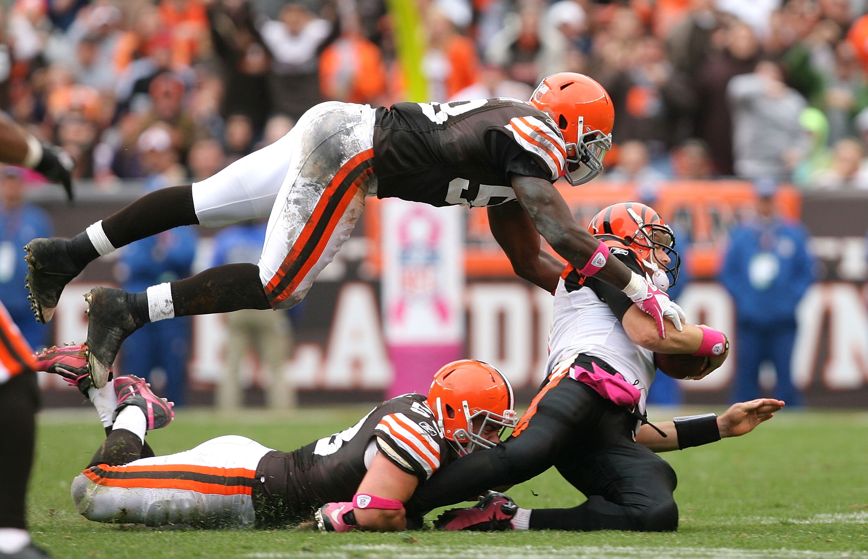 CLEVELAND - OCTOBER 03:  Linebackers Matt Roth #53 and Marcus Benard #58 of the Cleveland Browns sack quarterback Carson Palmer #9 of the Cincinnati Bengals at Cleveland Browns Stadium on October 3, 2010 in Cleveland, Ohio.  (Photo by Matt Sullivan/Getty