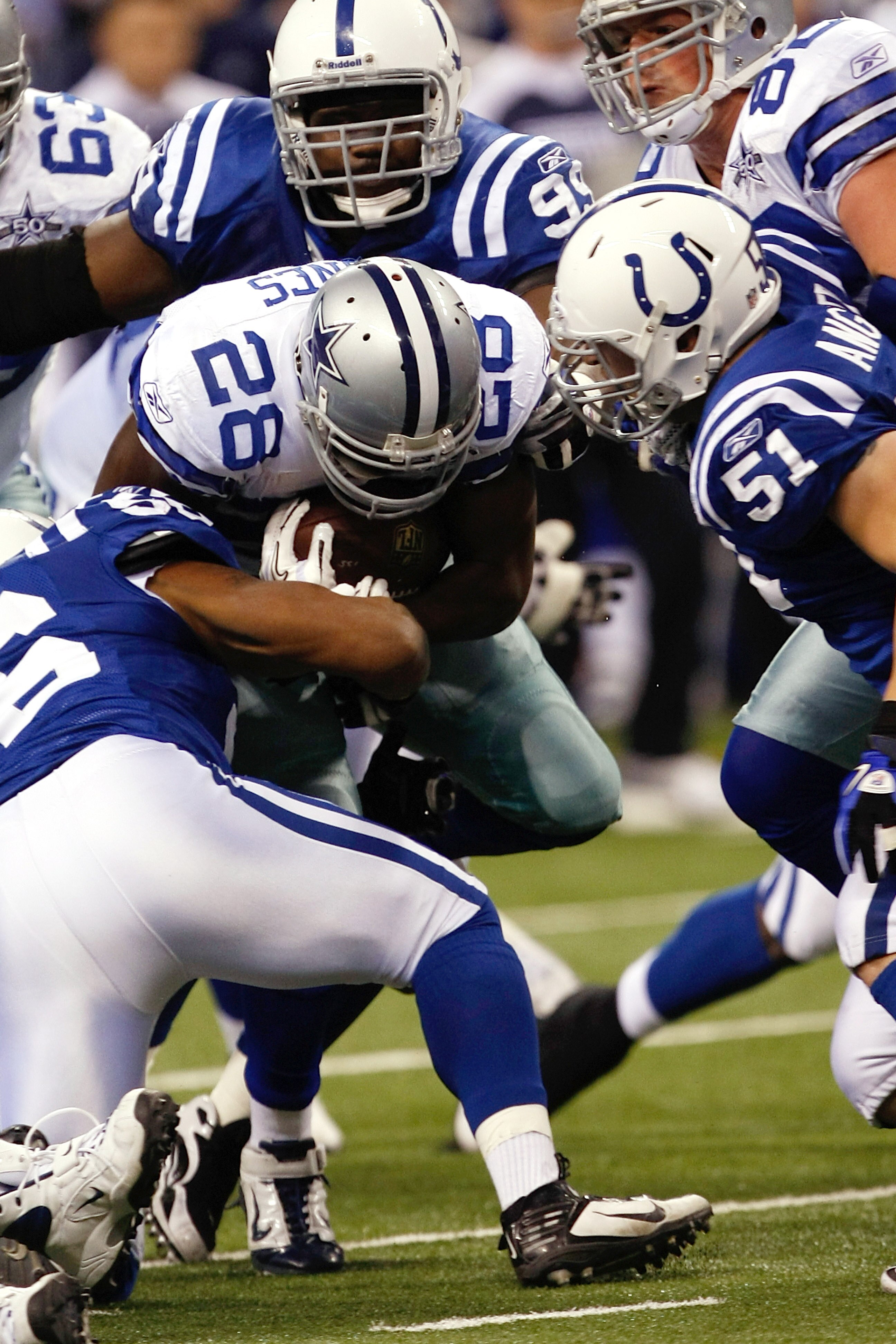 INDIANAPOLIS, IN - DECEMBER 05: Felix Jones #28 of the Dallas Cowboys runs as he is tackled by several defenders against the Indianapolis Colts at Lucas Oil Stadium on December 5, 2010 in Indianapolis, Indiana. The Cowboys defeated the Colts 38-35 in over