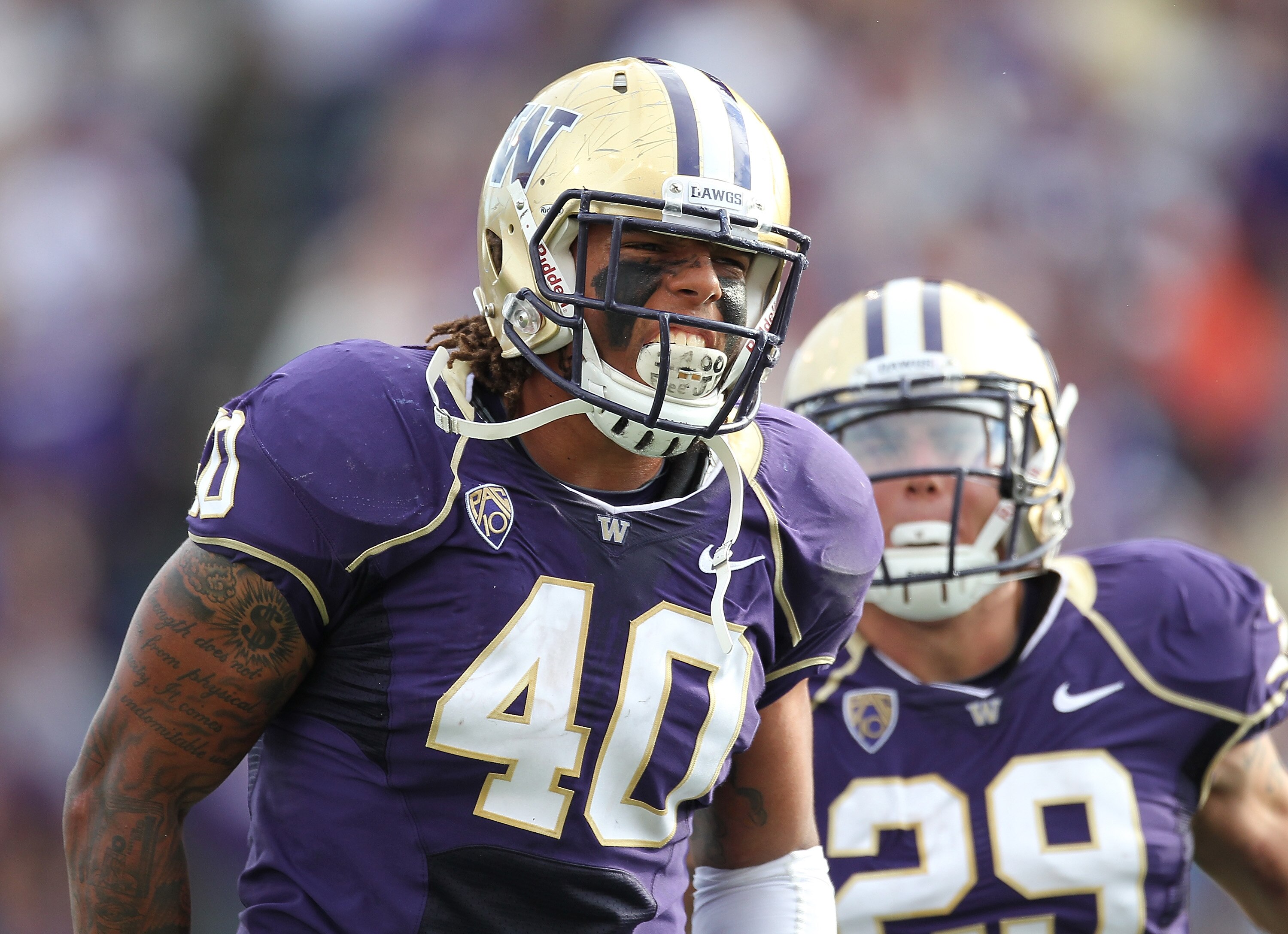 SEATTLE - SEPTEMBER 11:  Linebacker Mason Foster #40 of the Washington Huskies celebrates with Willis Wilson #29 after tackling quarterback Ryan Nassib #12 of the Syracuse Orange and causing a fumble on September 11, 2010 at Husky Stadium in Seattle, Wash