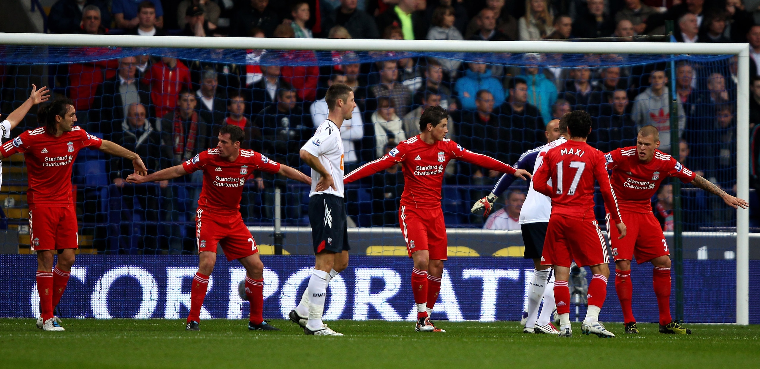BOLTON, ENGLAND - OCTOBER 31:  (L-R) Sotiros Kyrgiakos , Jamie Carragher, Fernando Torres and Martin Skrtel of Liverpool hold hands to defend a Bolton free kick during the Barclays Premier League match between Bolton Wanderers and Liverpool at the Reebok
