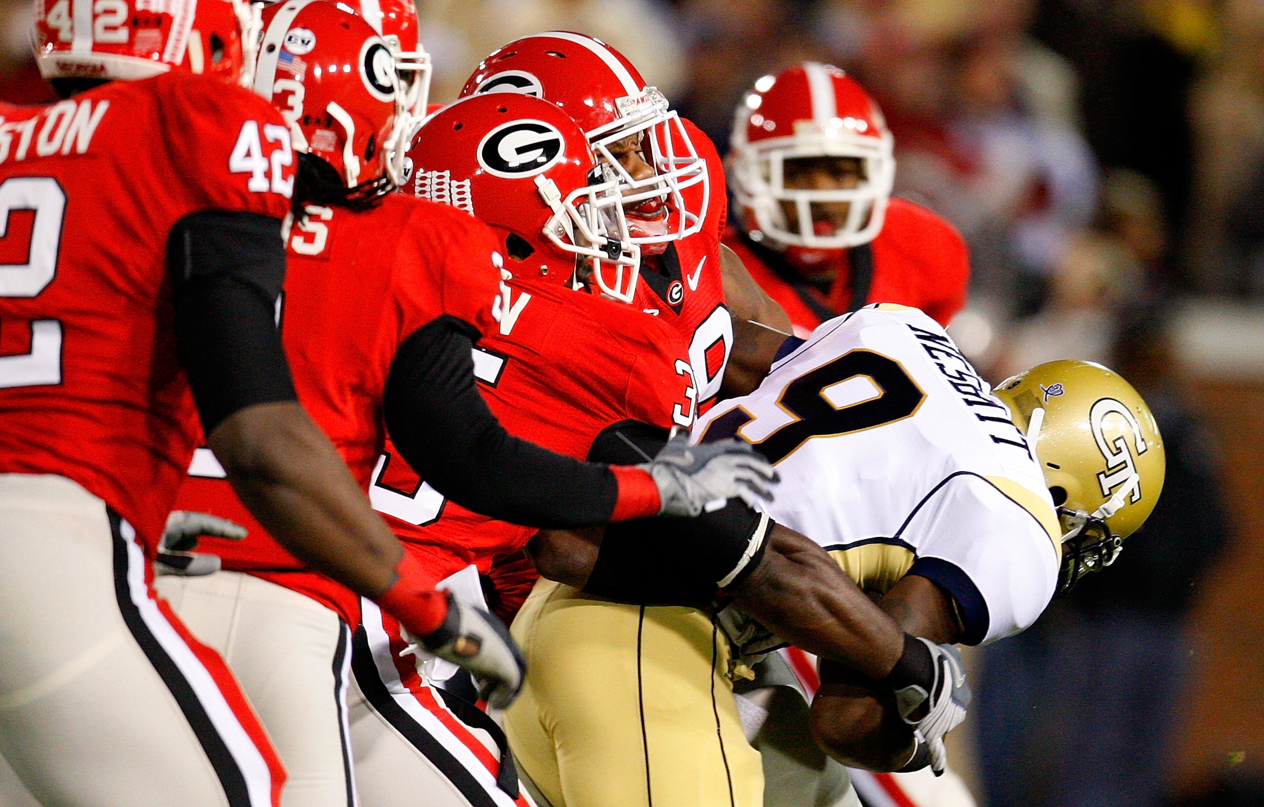 ATLANTA - NOVEMBER 28:  The defense of the Georgia Bulldogs tackles quarterback Josh Nesbitt #9 of the Georgia Tech Yellow Jackets at Bobby Dodd Stadium on November 28, 2009 in Atlanta, Georgia.  (Photo by Kevin C. Cox/Getty Images)