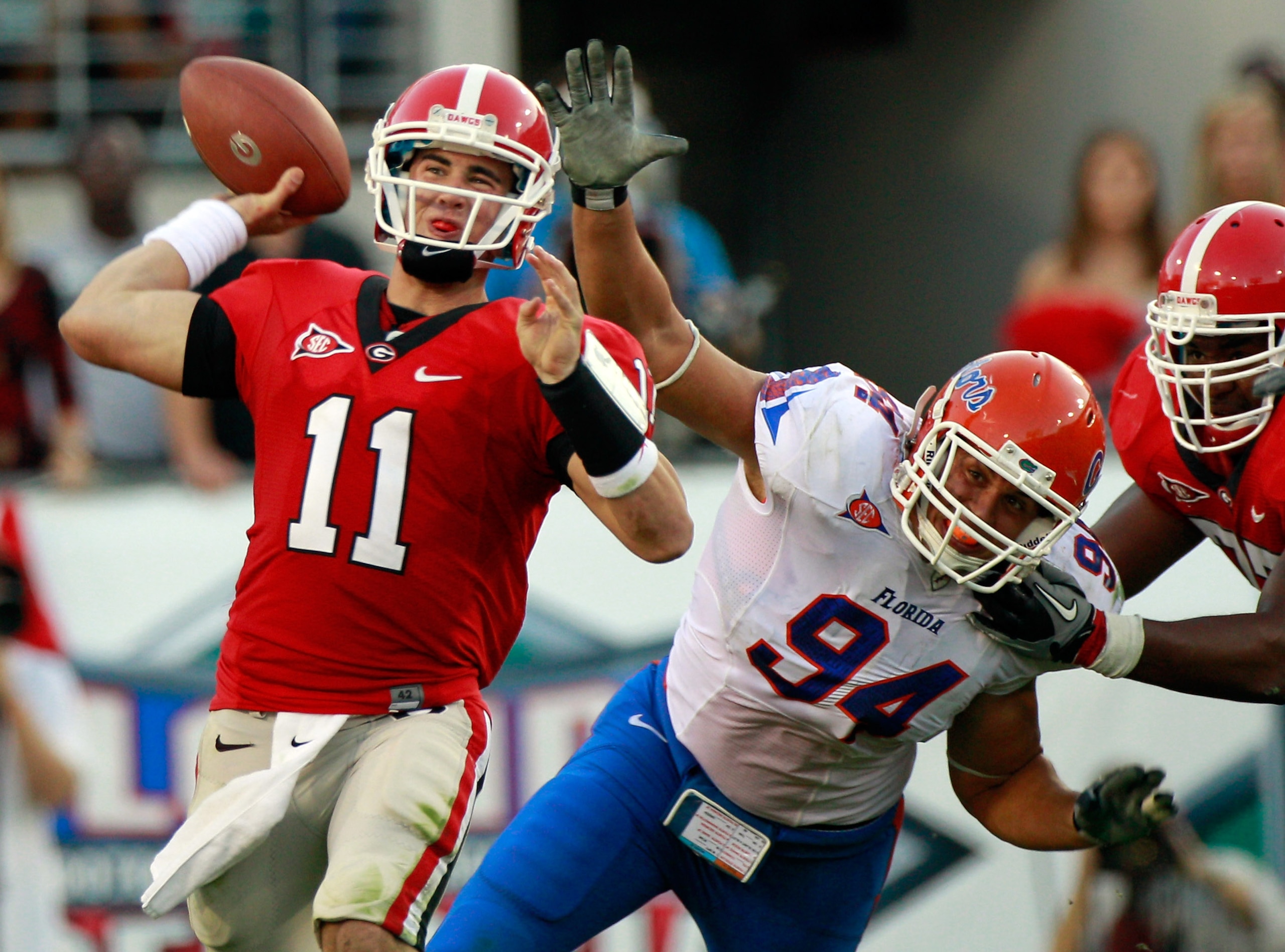 JACKSONVILLE, FL - OCTOBER 30:  Quarterback Aaron Murray #11 of the Georgia Bulldogs attempts a pass while being pressured by Justin Trattou #94 of the Florida Gators during the game at EverBank Field on October 30, 2010 in Jacksonville, Florida.  (Photo