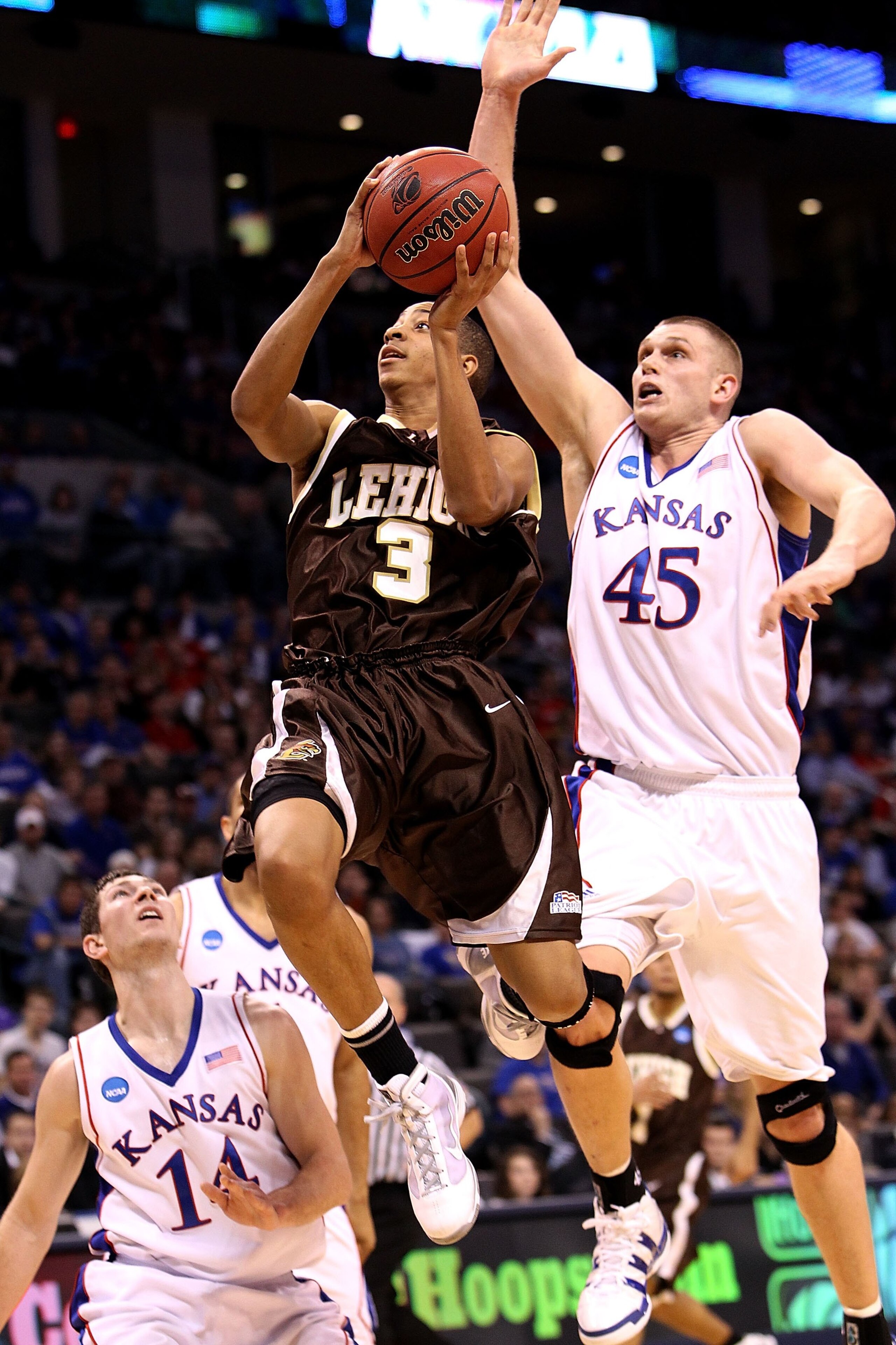 OKLAHOMA CITY - MARCH 18: CJ McCollum #3 of the Lehigh Mountain Hawks drives for a shot attempt past Cole Aldrich #45 of the Kansas Jayhawks during the first round of the 2010 NCAA men's basketball tournament at Ford Center on March 18, 2010 in Oklahoma OKLAHOMA CITY - MARCH 18: CJ McCollum #3 of the Lehigh Mountain Hawks drives for a shot attempt past Cole Aldrich #45 of the Kansas Jayhawks during the first round of the 2010 NCAA men's basketball tournament at Ford Center on March 18, 2010 in Oklahoma