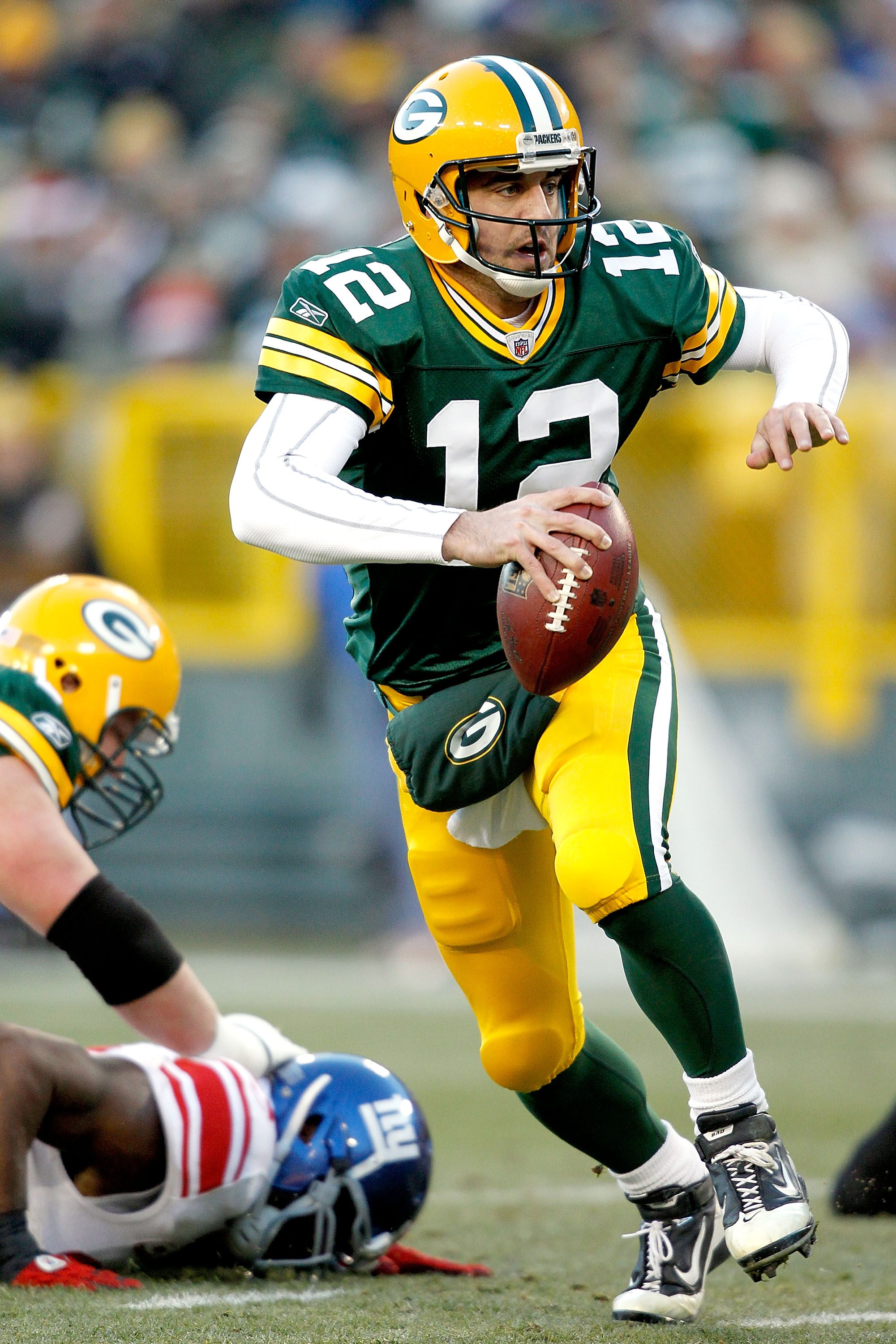 GREEN BAY, WI - DECEMBER 26:  Aaron Rodgers #12 of the Green Bay Packers is chased out of the pocket against the New York Giants at Lambeau Field on December 26, 2010 in Green Bay, Wisconsin.  (Photo by Matthew Stockman/Getty Images)