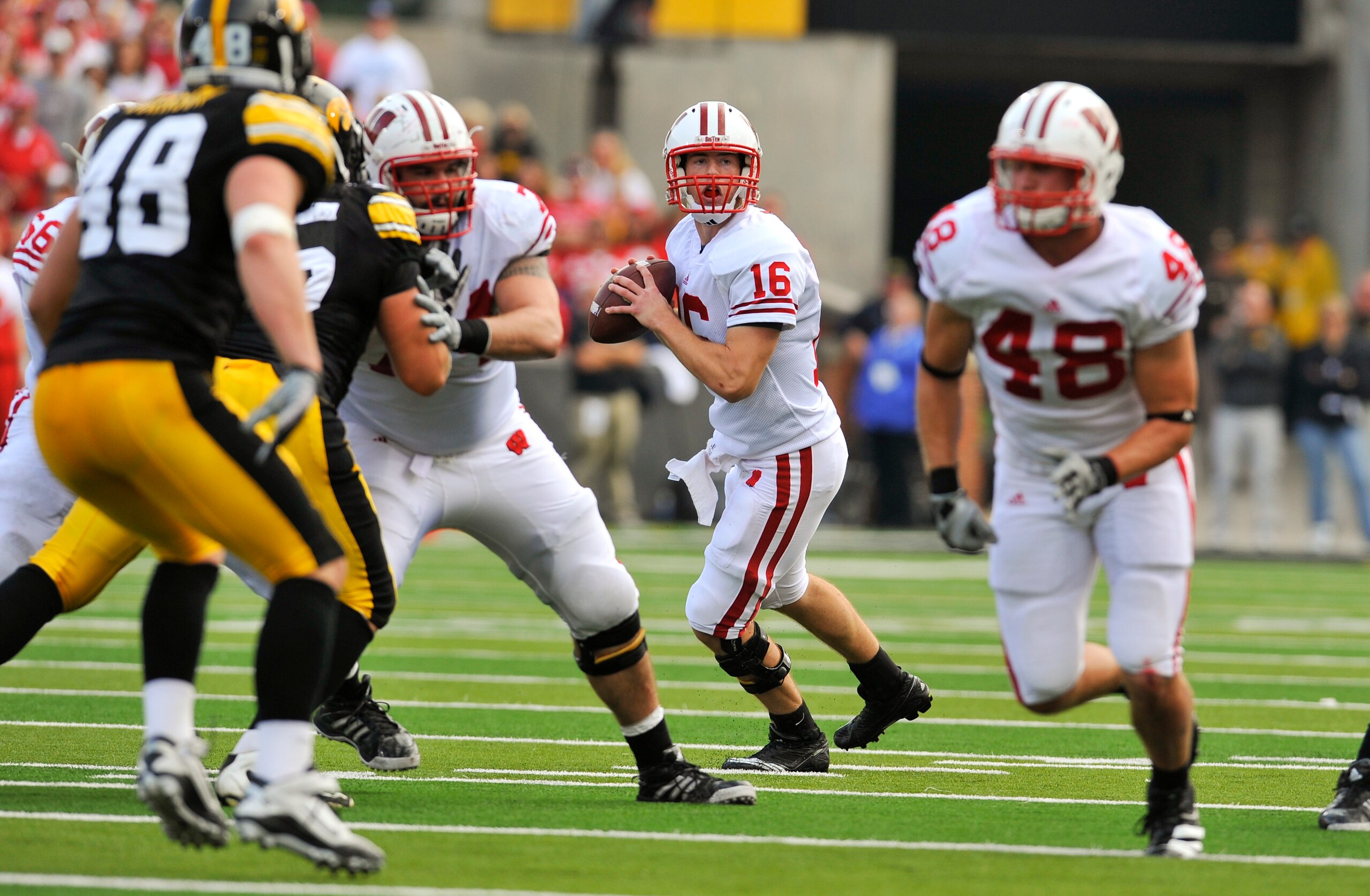 IOWA CITY, IA - OCTOBER 23- Quarterback Scott Tolzien #16 of the Wisconsin Badgers throws under pressure from the University of Iowa Hawkeyes during the first half of play at Kinnick Stadium on October 23, 2010 in Iowa City, Iowa. Wisconsin won 31-30 over