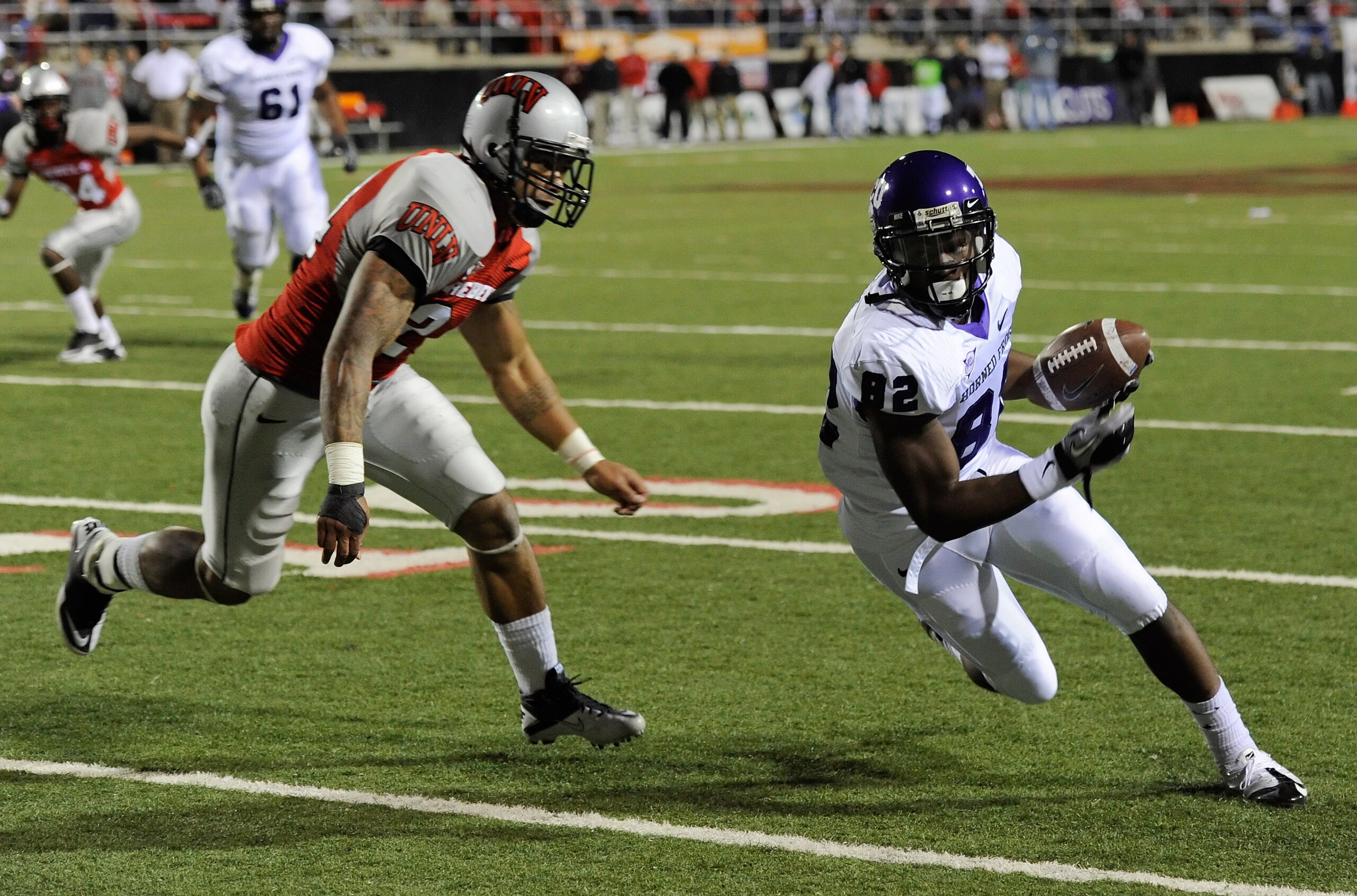 LAS VEGAS - OCTOBER 30:  Josh Boyce #82 of the Texas Christian University Horned Frogs runs for yardage after a reception against Starr Fuimaono #24 of the UNLV Rebels during the second quarter of their game at Sam Boyd Stadium October 30, 2010 in Las Veg