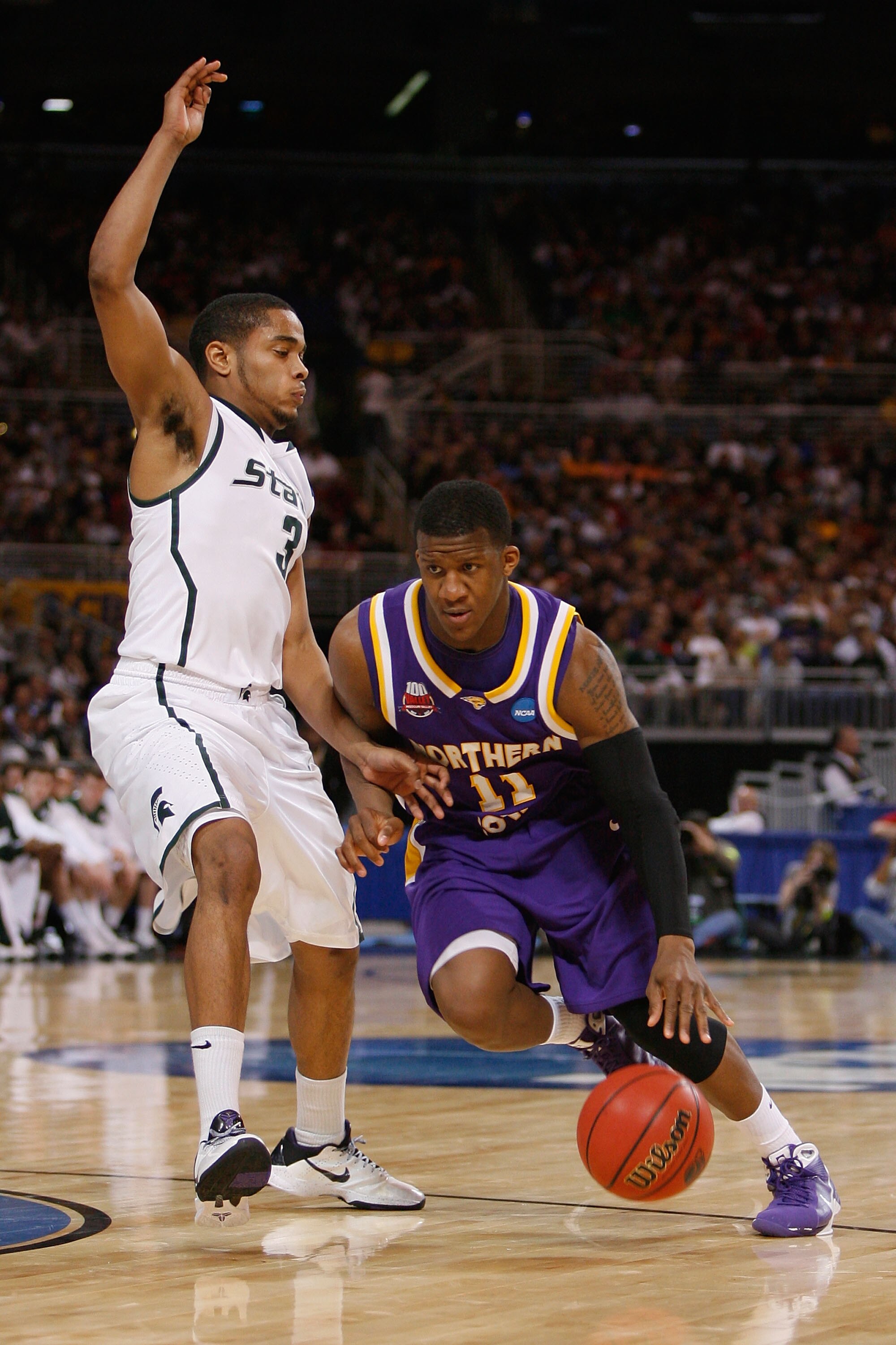 ST. LOUIS, MO. - MARCH 26: Kwadzo Ahelegbe #11 of the Northern Iowa Panthers drives past Chris Allen #3 of the Michigan State Spartans during the midwest regional semifinal of the 2010 NCAA men's basketball tournament at the Edward Jones Dome on March 26,