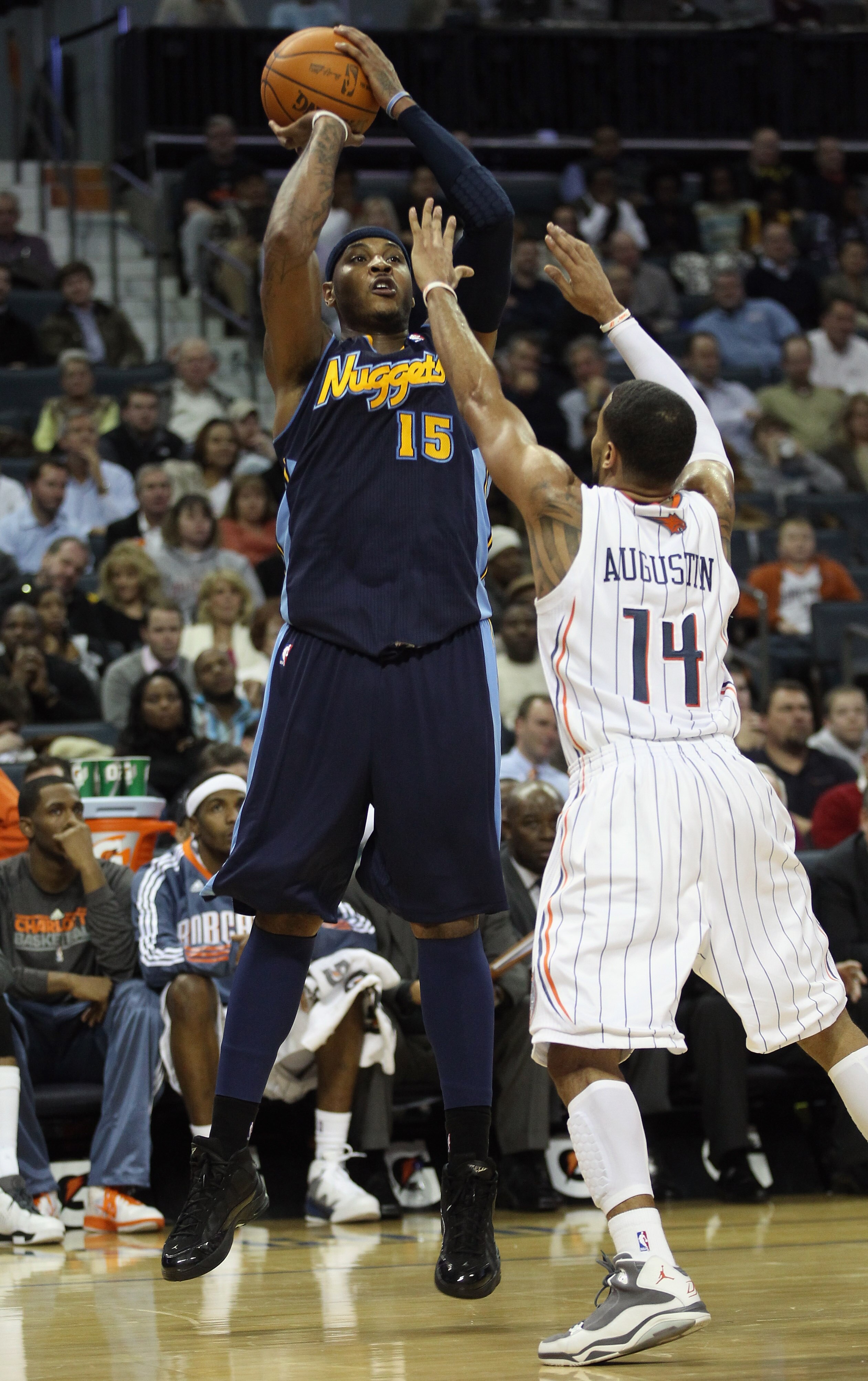 CHARLOTTE, NC - DECEMBER 07:  Carmelo Anthony #15 of the Denver Nuggets shoots over D.J. Augustin #14 of the Charlotte Bobcats during their game at Time Warner Cable Arena on December 7, 2010 in Charlotte, North Carolina.  NOTE TO USER: User expressly ack