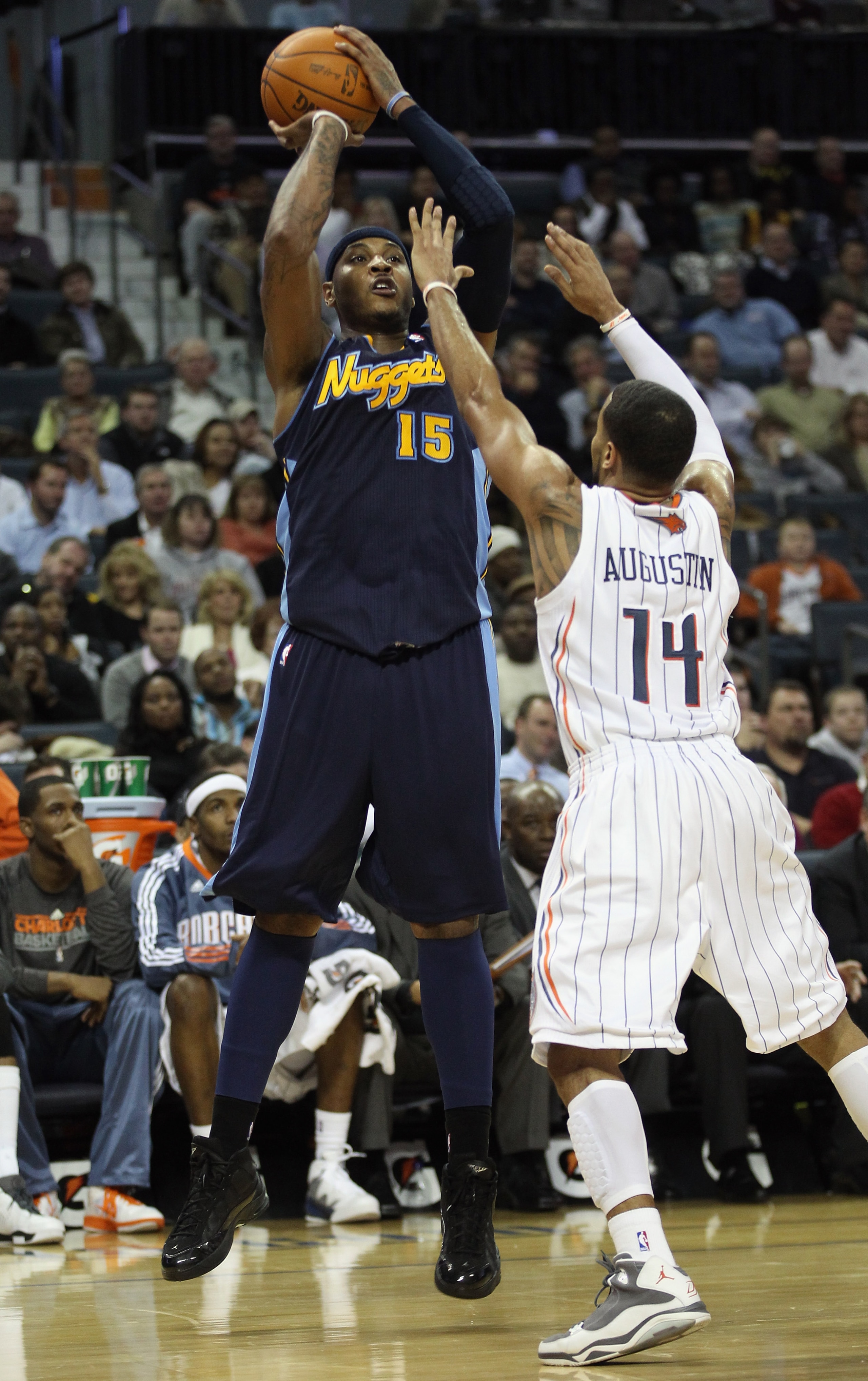 CHARLOTTE, NC - DECEMBER 07:  Carmelo Anthony #15 of the Denver Nuggets shoots over D.J. Augustin #14 of the Charlotte Bobcats during their game at Time Warner Cable Arena on December 7, 2010 in Charlotte, North Carolina.  NOTE TO USER: User expressly ack