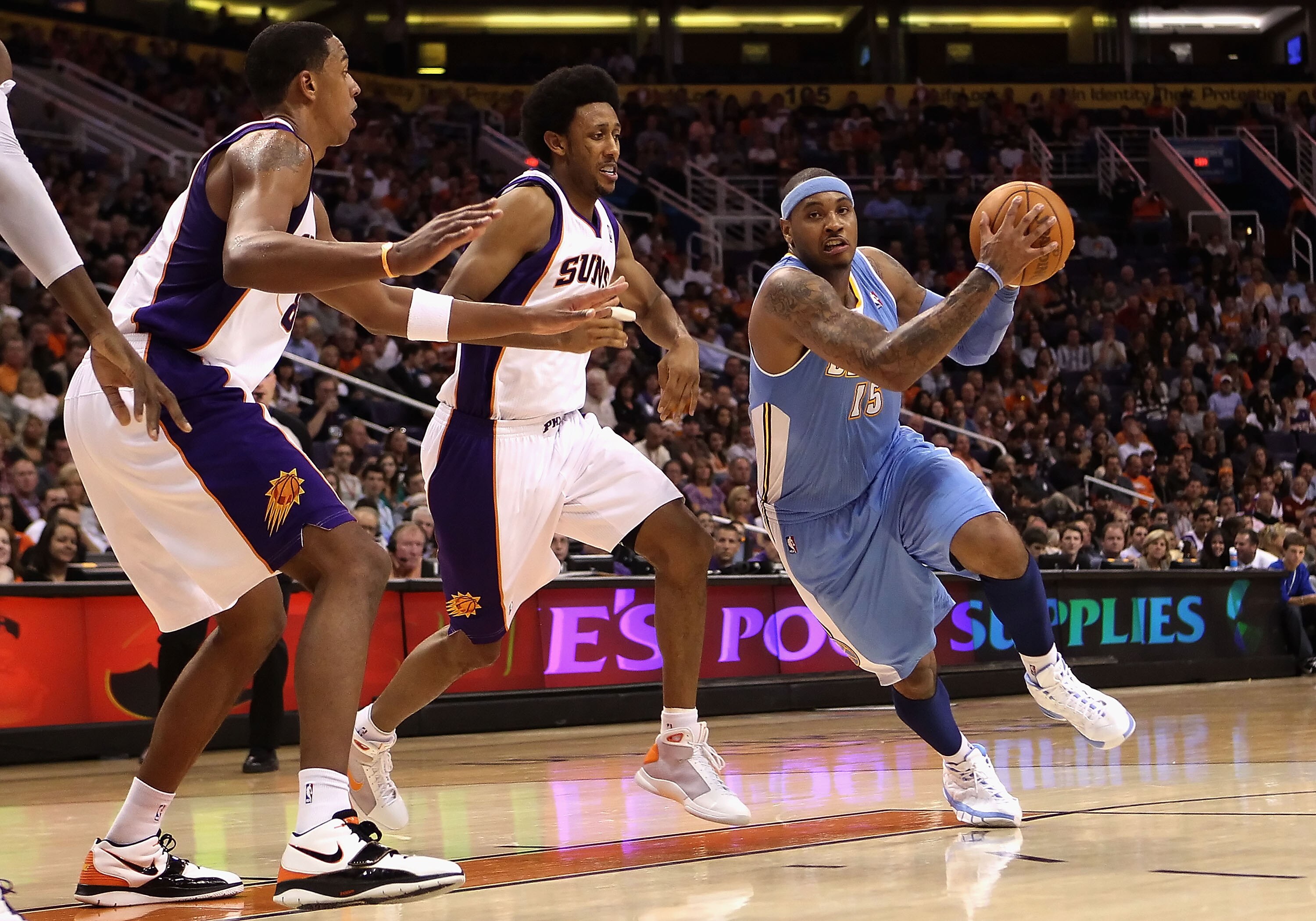 PHOENIX - NOVEMBER 15:  Carmelo Anthony #15 of the Denver Nuggets drives the ball past Josh Childress #1 of the Phoenix Suns during the NBA game at US Airways Center on November 15, 2010 in Phoenix, Arizona.  The Suns defeated the Nuggets 100-94.  NOTE TO
