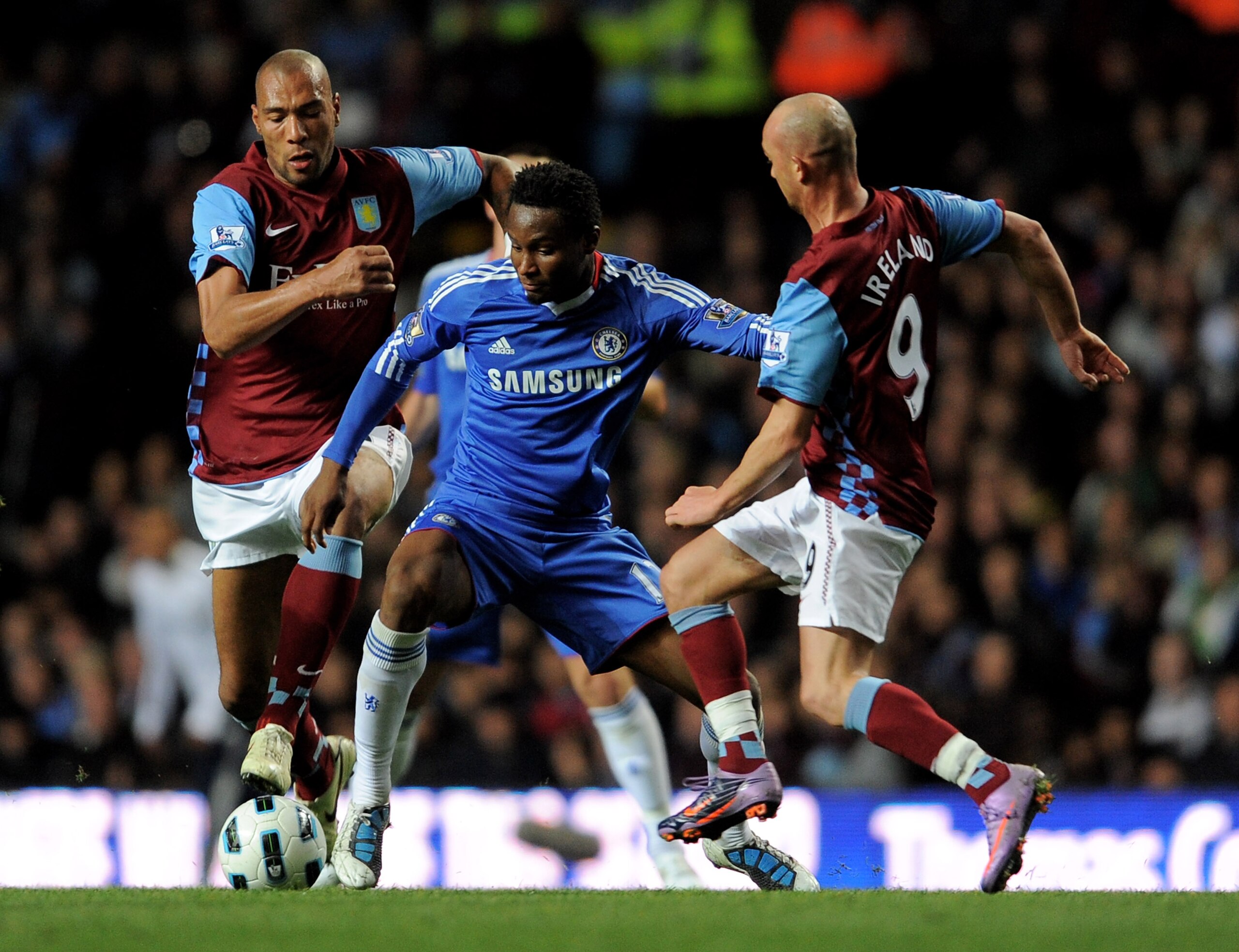 BIRMINGHAM, ENGLAND - OCTOBER 16:  John Obi Mikel of Chelsea is challenged by Stephen Ireland and John Carew (L) of Aston Villa during the Barclays Premier League match between Aston Villa and Chelsea at Villa Park on October 16, 2010 in Birmingham, Engla