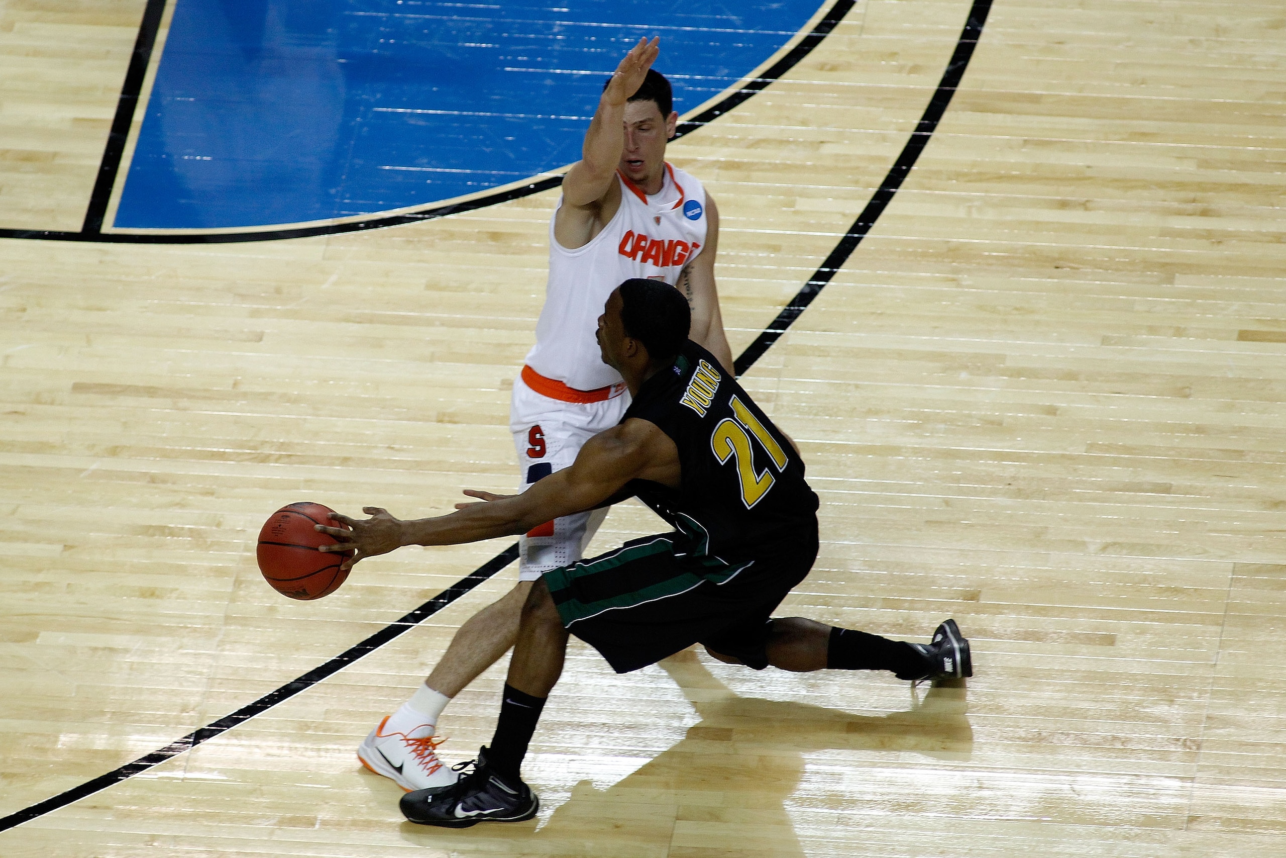 BUFFALO, NY - MARCH 19:  Garvey Young #21 of the Vermont Catamounts passes against Andy Rautins #1 of the Syracuse Orange during the first round of the 2010 NCAA men's basketball tournament at HSBC Arena on March 19, 2010 in Buffalo, New York.  (Photo by