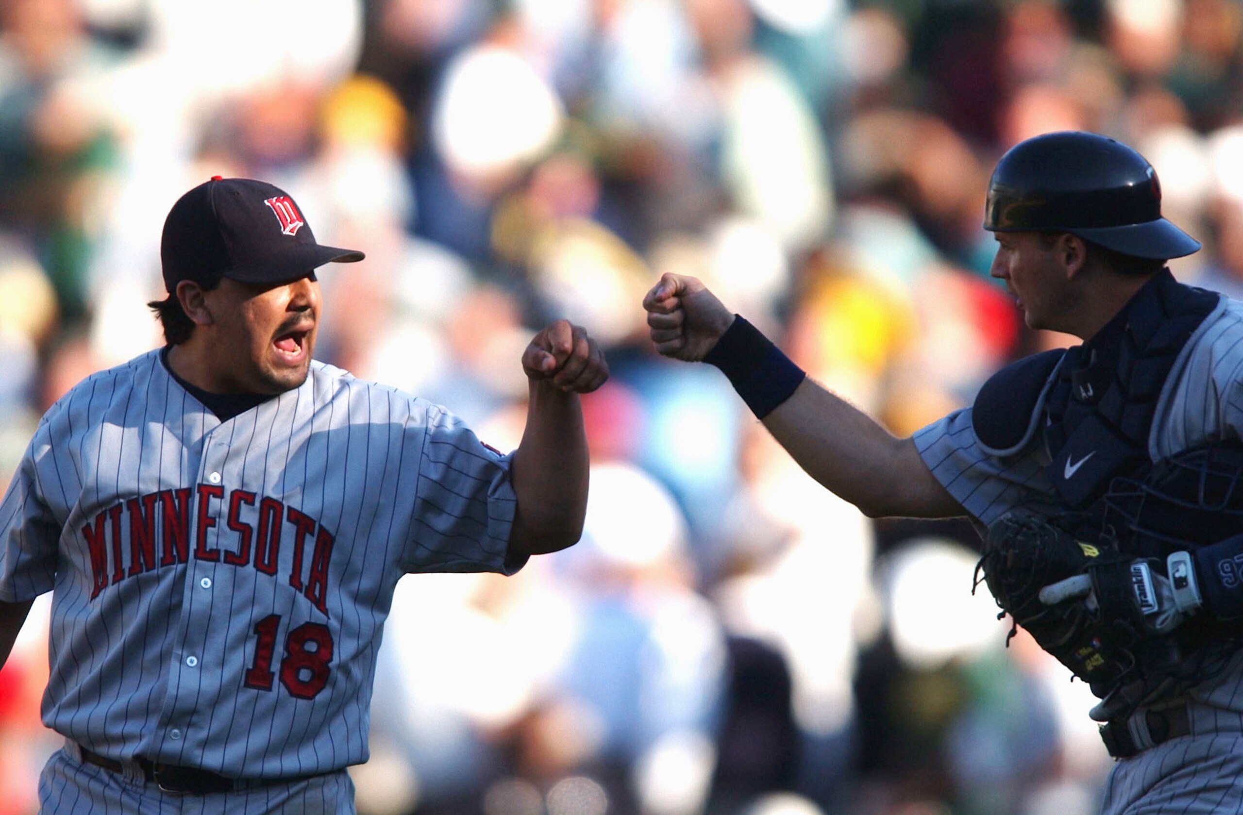OAKLAND, CA - OCTOBER 1:  Eddie Guardardo #18 of the Minnesota Twins celebrates a 7-5 victory with catcher A.J. Pierzynski #126 against the Oakland Athletics during game one in the American League Western Division Series  on October 1, 2002 at the Network