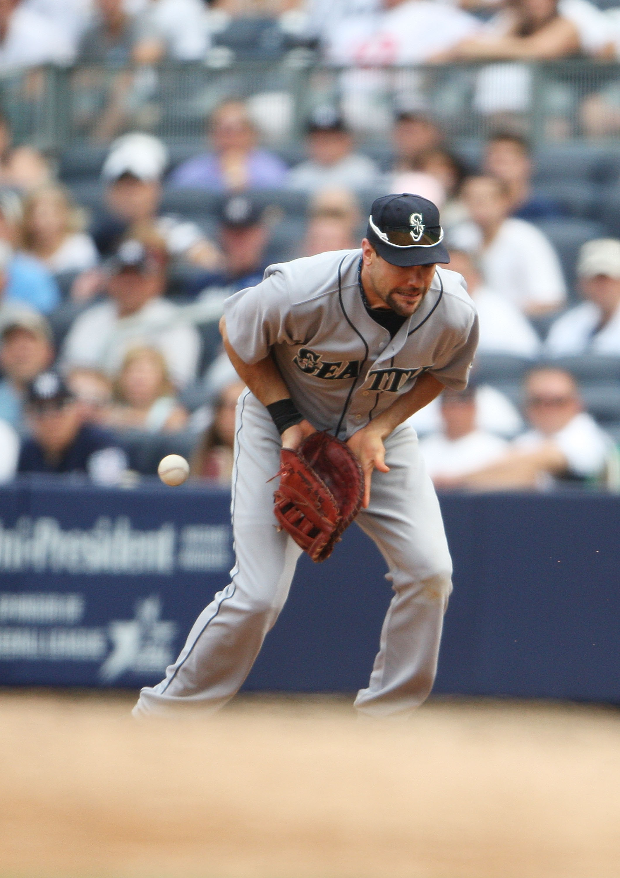 NEW YORK - AUGUST 21: Casey Kotchman #13 of the Seattle Mariners misses a one-run hit from Curtis Granderson #14 (not seen) of the New York Yankees in the eigth inning at Yankee Stadium on August 21, 2010 in the Bronx borough of New York City.  The Yankee