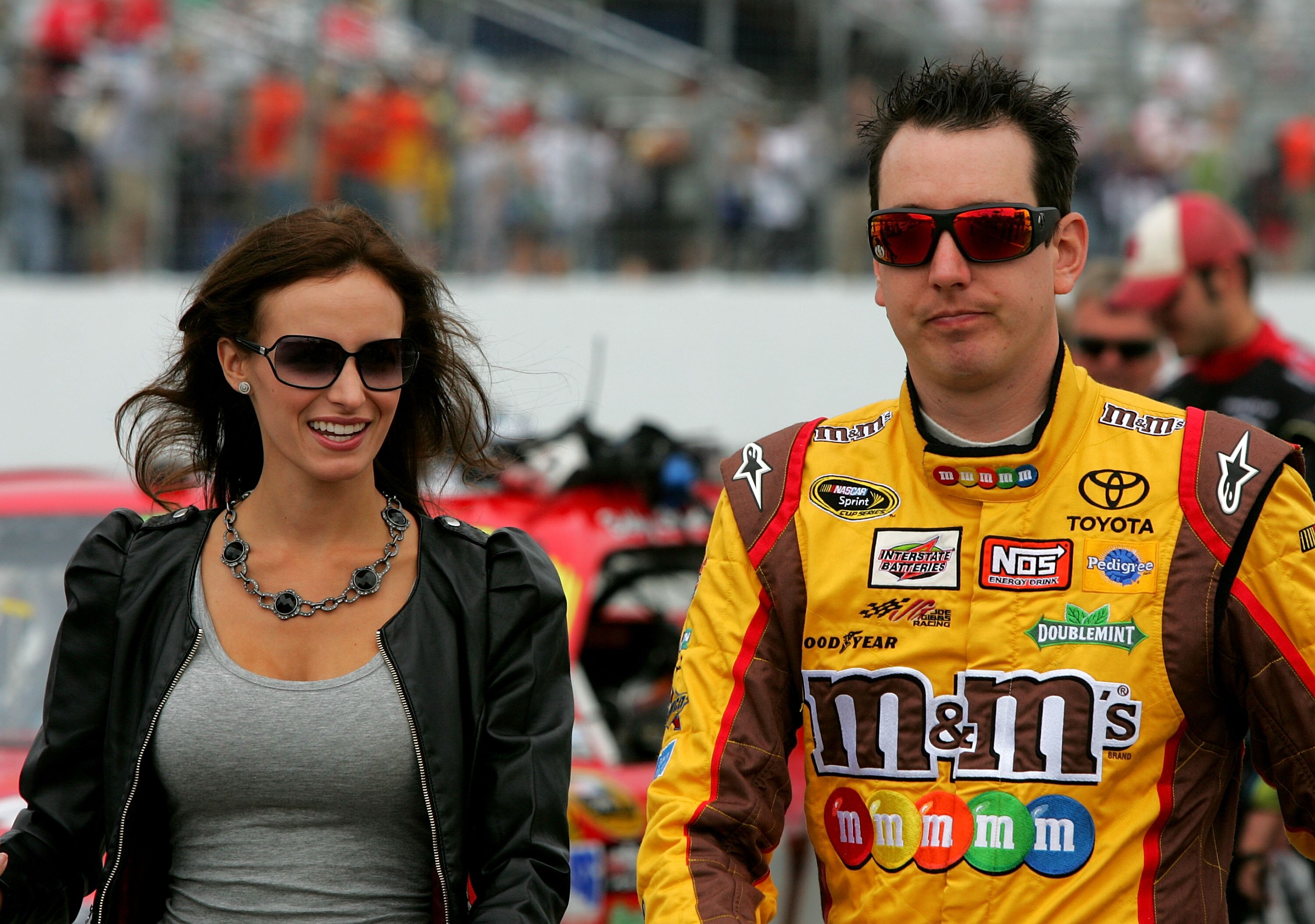 LOUDON, NH - SEPTEMBER 19: Kyle Busch, driver of the #18 M&M's Toyota walks down pit road with fiancee Samantha Sarcinella prior to the start of the NASCAR Sprint Cup Series Sylvania 300 at New Hampshire Motor Speedway on September 19, 2010 in Loudon, New