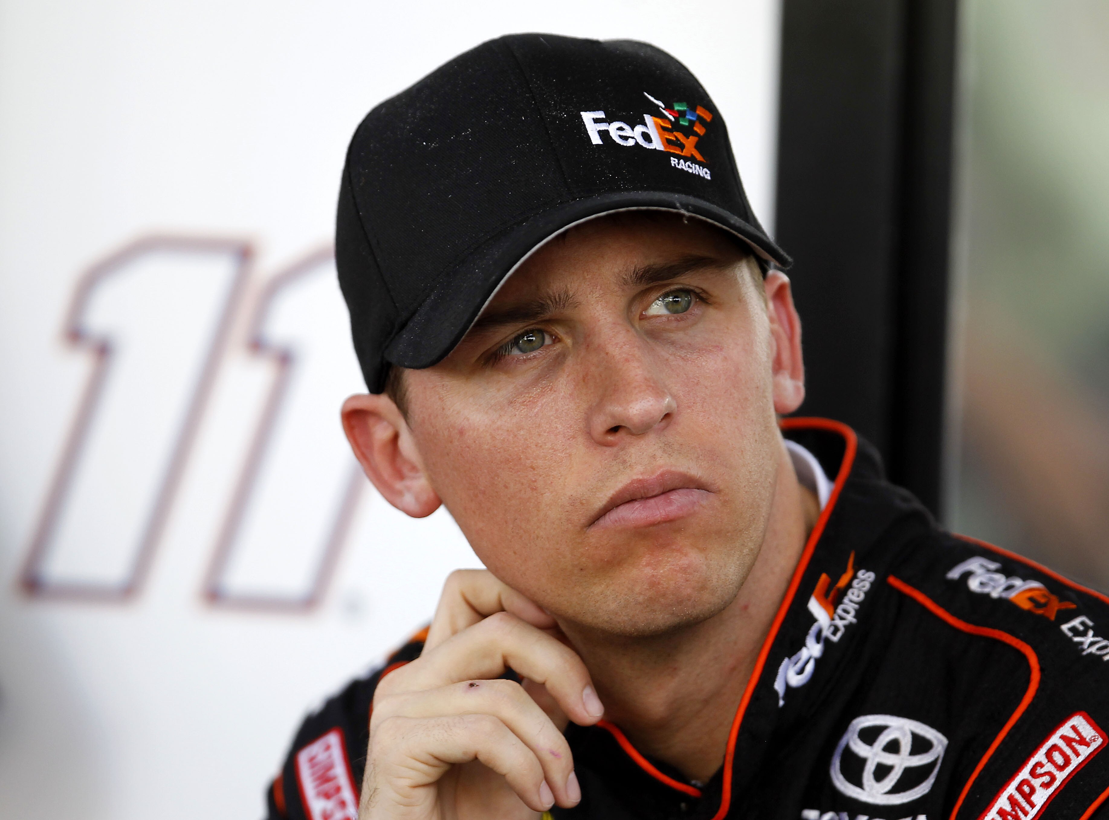 HOMESTEAD, FL - NOVEMBER 19:  Denny Hamlin, driver of the #11 FedEx Toyota, sits by his team hauler in the garage area during practice for the NASCAR Sprint Cup Series Ford 400 at Homestead-Miami Speedway on November 19, 2010 in Homestead, Florida.  (Phot