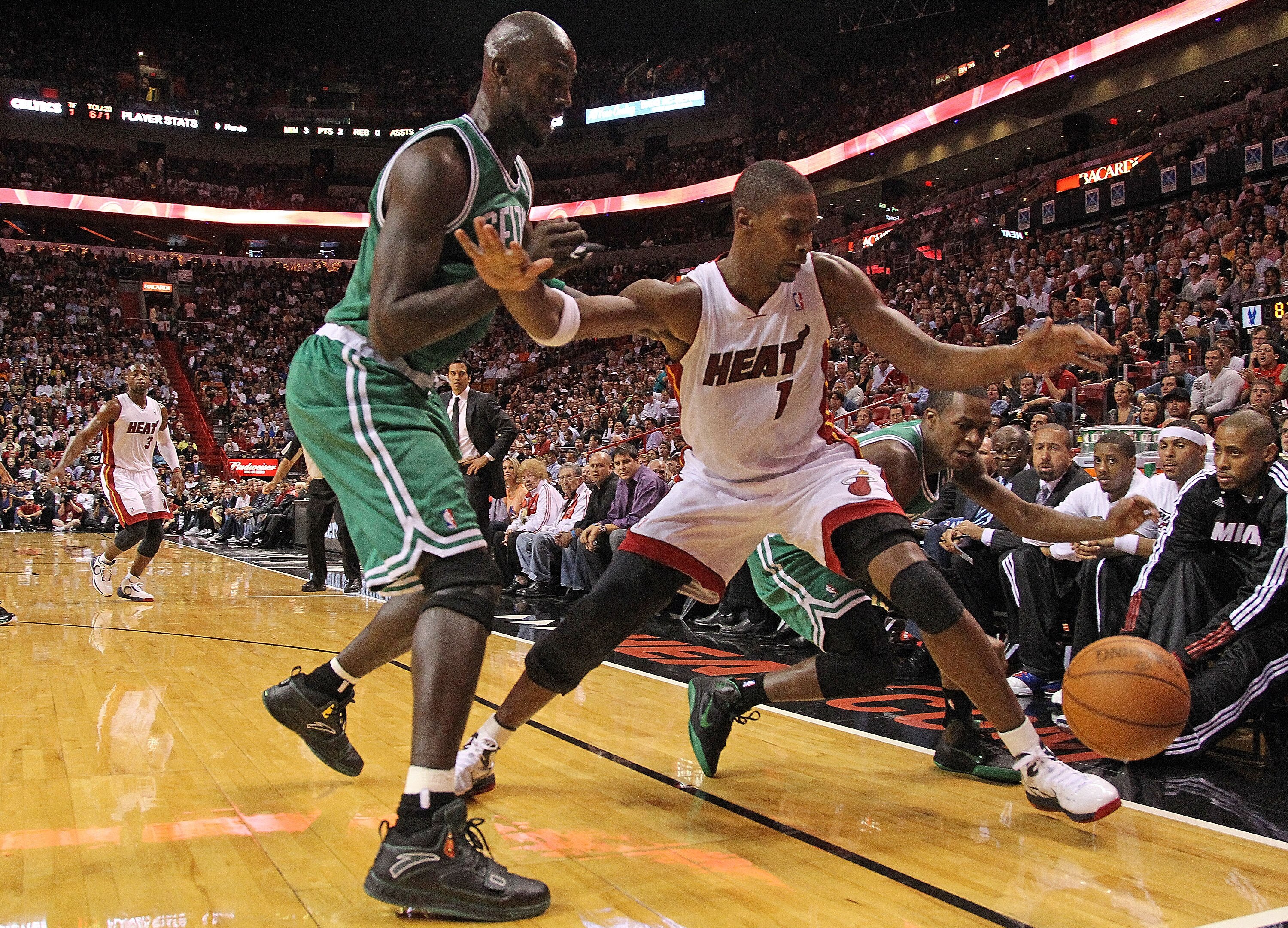 MIAMI - NOVEMBER 11:  Chris Bosh #1 of the Miami Heat chases a loose ball against Kevin Garnett #5 and Rajon Rondo #9  during a game against the Boston Celtics at American Airlines Arena on November 11, 2010 in Miami, Florida. NOTE TO USER: User expressly