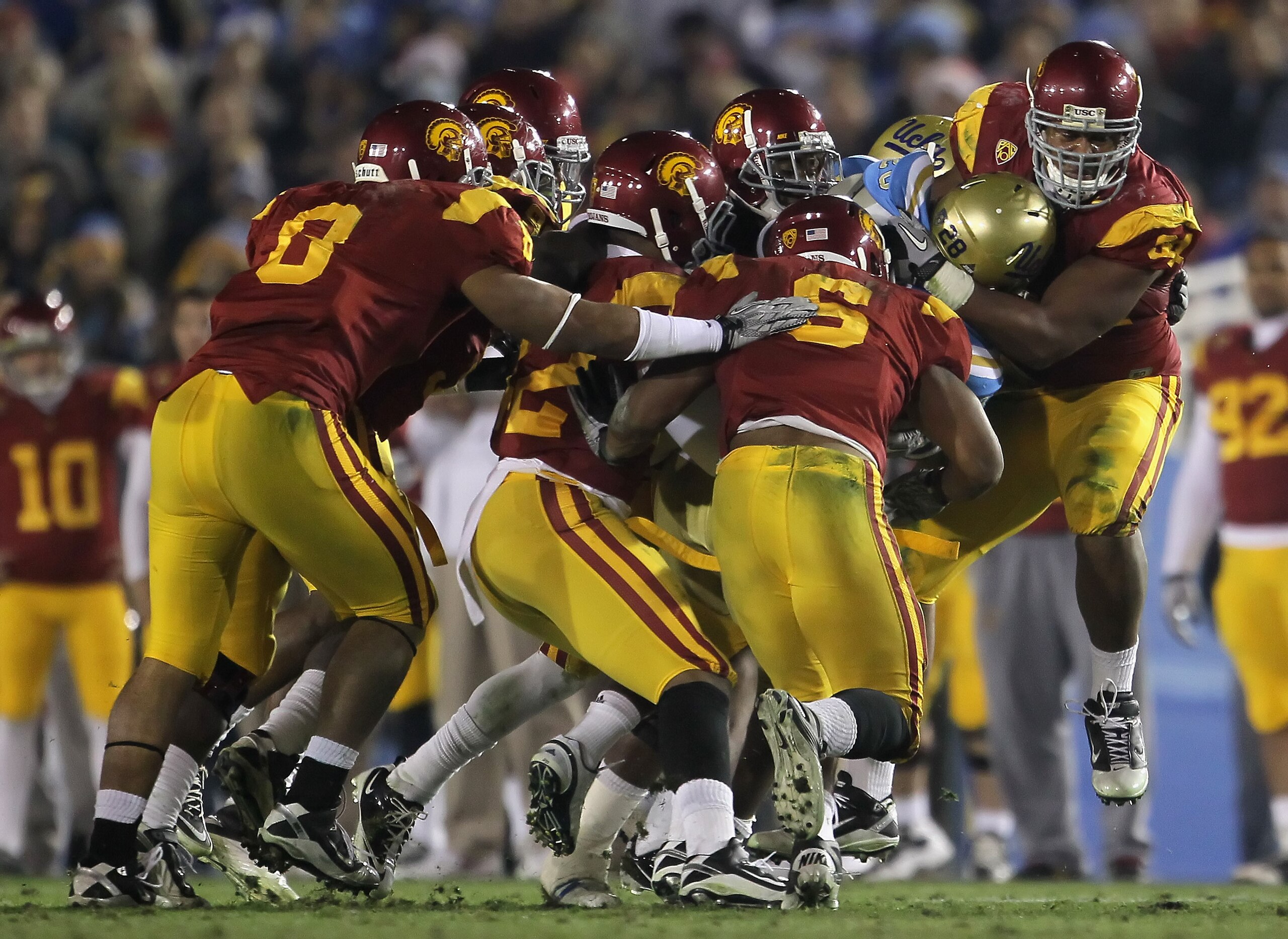 PASADENA, CA - DECEMBER 04:  Chris Galippo (R) #54 of the USC Trojans tackles Malcolm Jones #28 of the UCLA Bruins during the second half at the Rose Bowl on December 4, 2010 in Pasadena, California. USC defeated UCLA 28-14.  (Photo by Jeff Gross/Getty Im