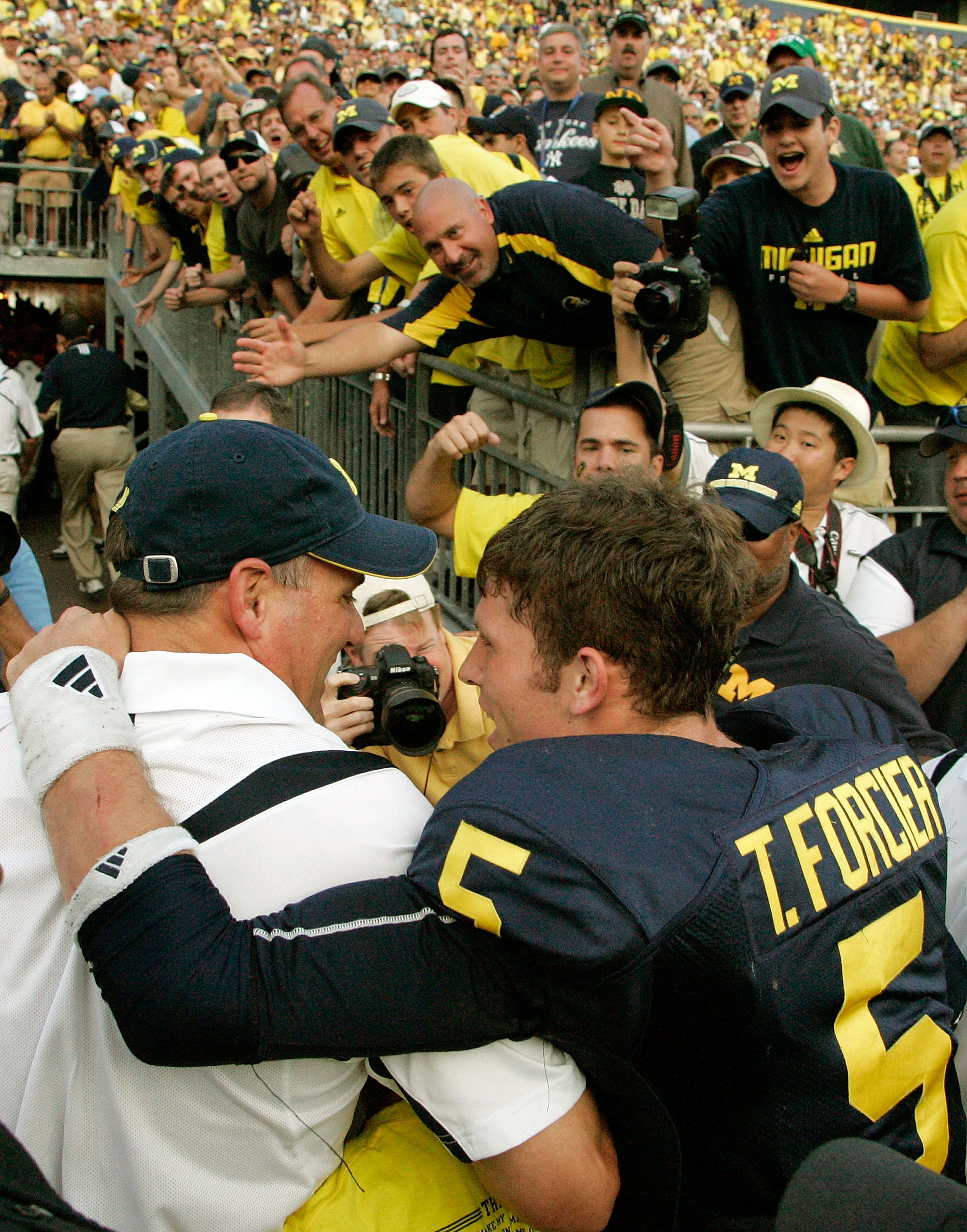 ANN ARBOR, MI - SEPTEMBER 12:  Quarterback Tate Forcier #5 embraces head coach Rich Rodriguez as they approach the tunnel after beating Notre Dame 38-34 at Michigan Stadium on September 12, 2009 in Ann Arbor, Michigan.  (Photo by Domenic Centofanti/Getty