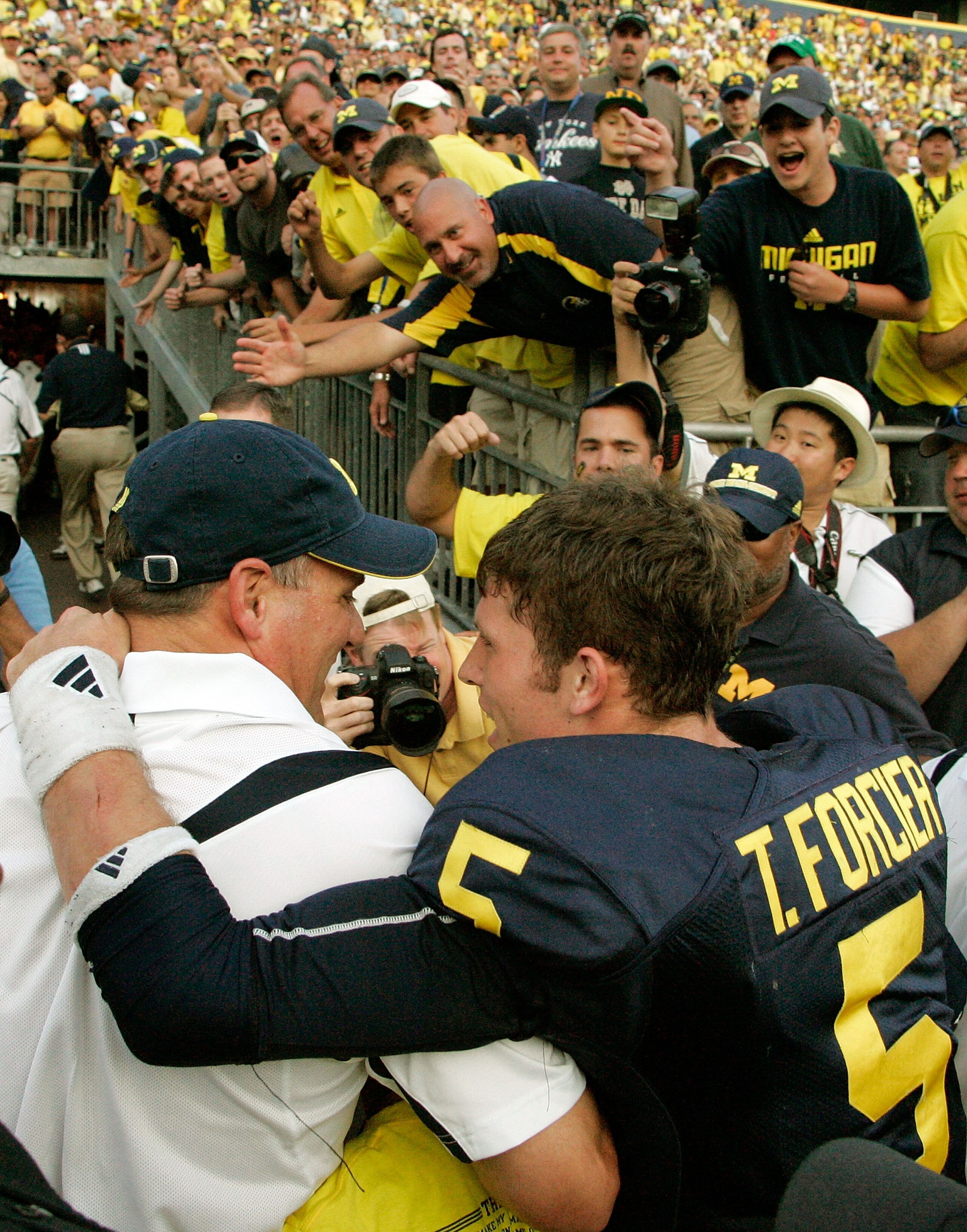 ANN ARBOR, MI - SEPTEMBER 12:  Quarterback Tate Forcier #5 embraces head coach Rich Rodriguez as they approach the tunnel after beating Notre Dame 38-34 at Michigan Stadium on September 12, 2009 in Ann Arbor, Michigan.  (Photo by Domenic Centofanti/Getty