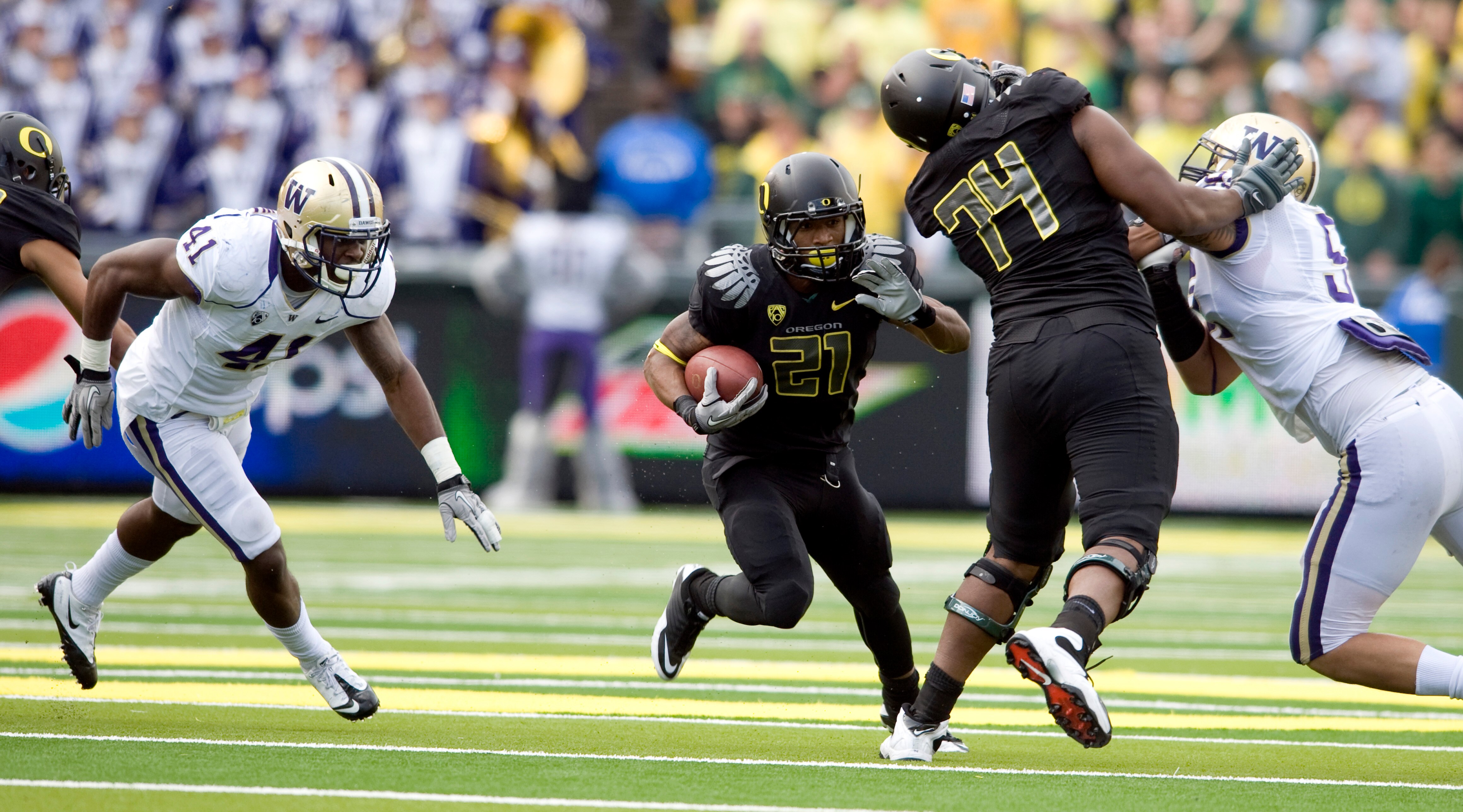 EUGENE, OR - NOVEMBER 6: Linebacker Victor Aiyewa #41 of the Washington Huskies tries to tackle running back LaMichael James #21 of the Oregon Ducks as offensive tackle Darrion Weems #74 of the Ducks blocks defensive tackle Sione Potoa'e #55 of the Huskie