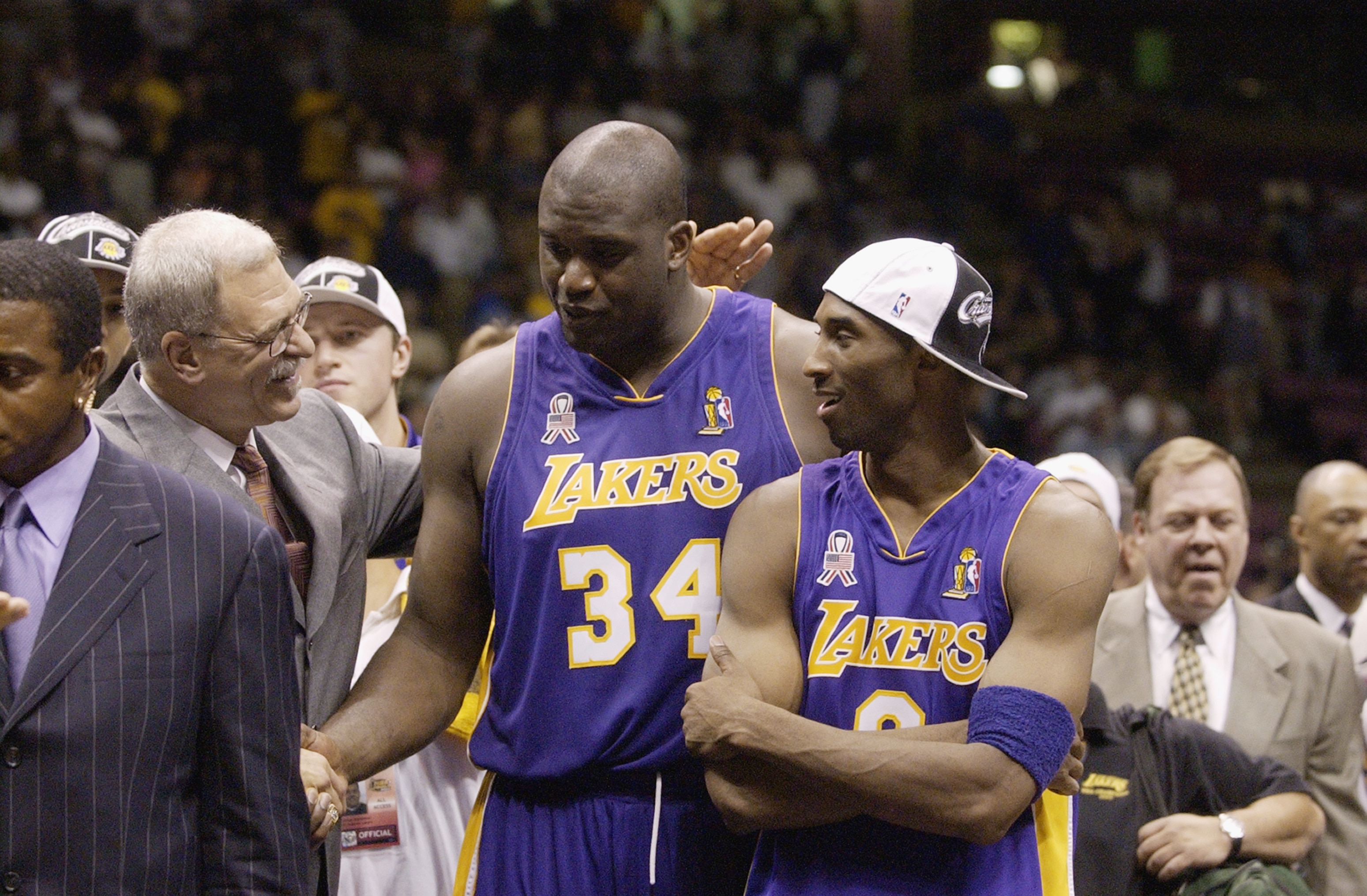 EAST RUTHERFORD, NJ - JUNE 12: Head coach Phil Jackson of the Los Angeles Lakers congratulates Shaquille O'Neal #34 and Kobe Bryant #8 of the Lakers after defeating the New Jersey Nets in Game four of the 2002 NBA Finals on June 12, 2002 at Continental Ai