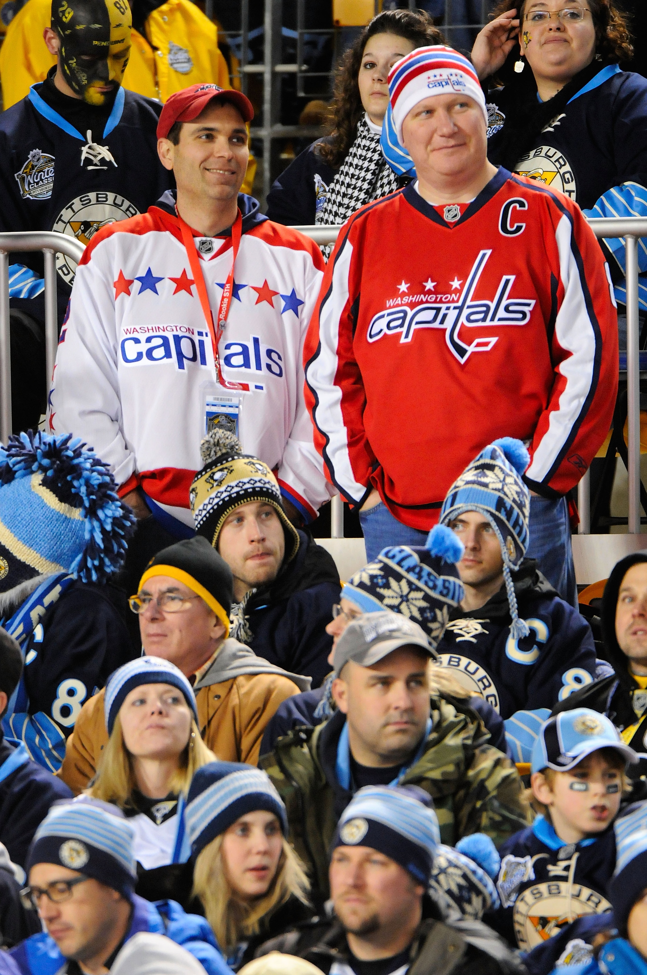 PITTSBURGH, PA - JANUARY 01:  Two Washington Capitals fans sit among a crowd of Pittsburgh Penguins fans during the 2011 NHL Bridgestone Winter Classic at Heinz Field on January 1, 2011 in Pittsburgh, Pennsylvania.  (Photo by Jamie Sabau/Getty Images)