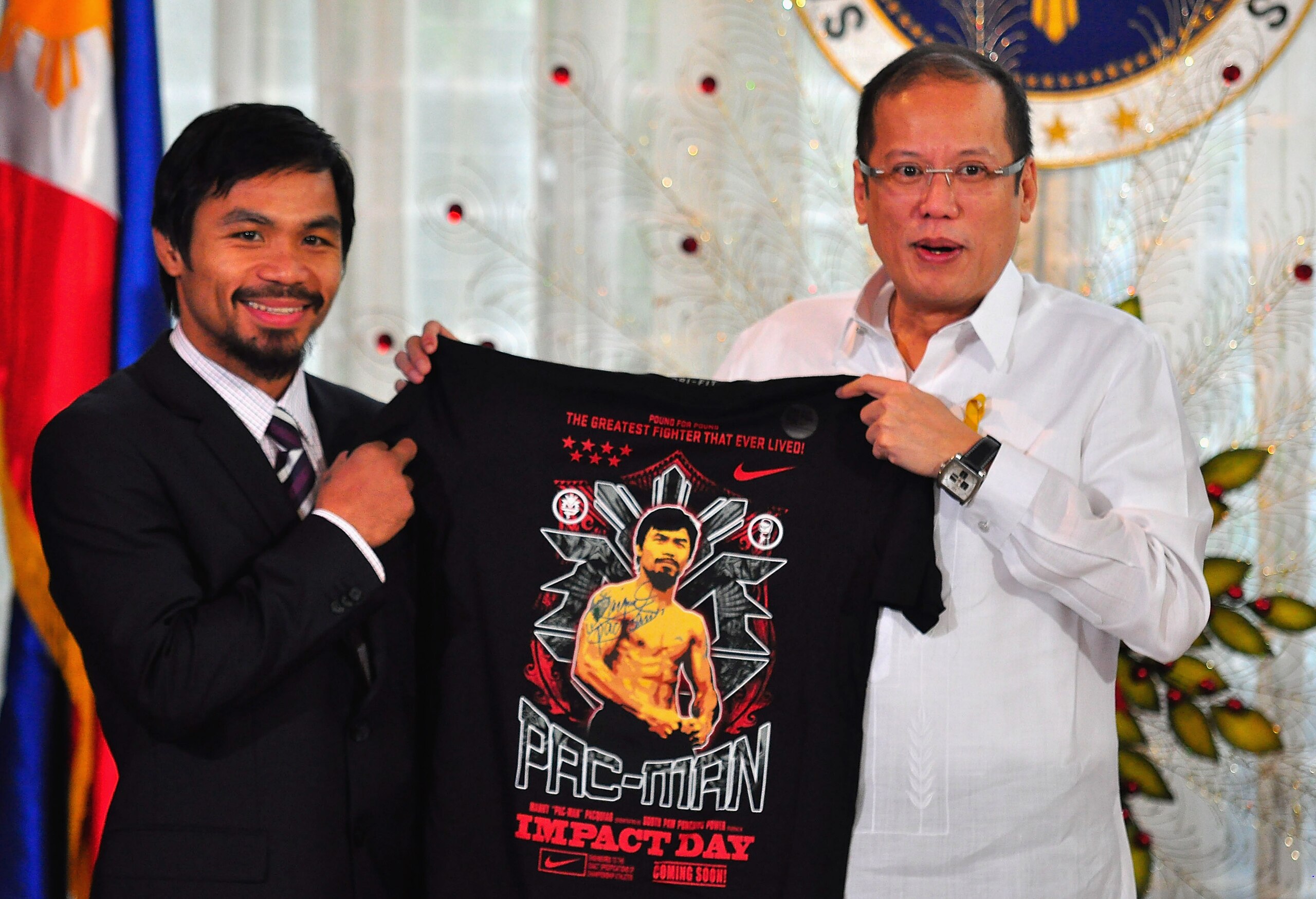 MANILA, PHILIPPINES - NOVEMBER 20:  Boxer and congressman, Manny Pacquiao gives President Benigno Aquino III a shirt and memorabilia following his win of the WBC super welterweight crown against Mexican Antonio Margarito on November 20, 2010 in Manila, Ph
