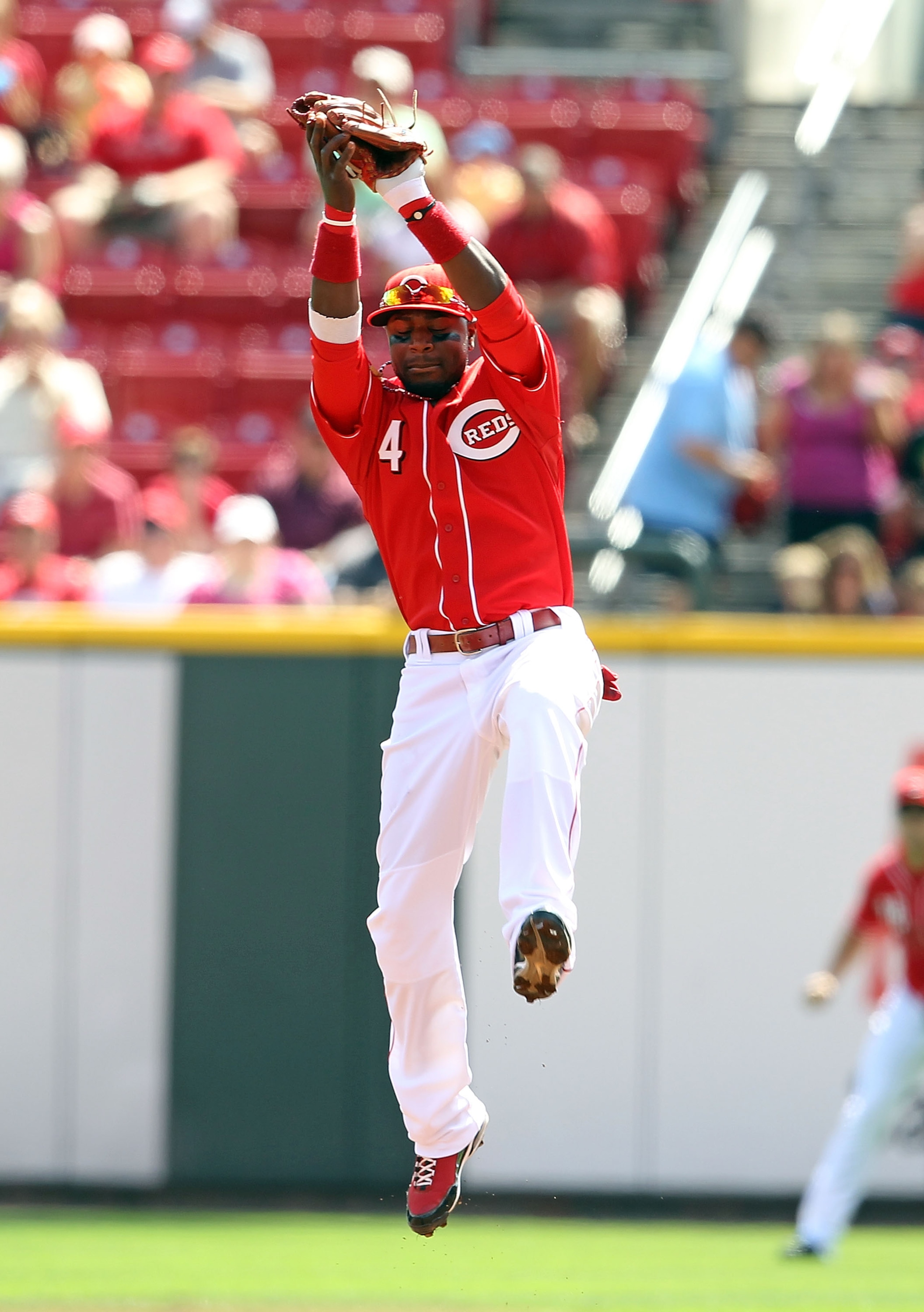CINCINNATI - SEPTEMBER 12: Brandon Phillips #4 of the Cincinnati Reds leaps to catch a ball for an out  during the game against the Pittsburgh Pirates at Great American Ballpark on September 12, 2010 in Cincinnati, Ohio.  (Photo by Andy Lyons/Getty Images
