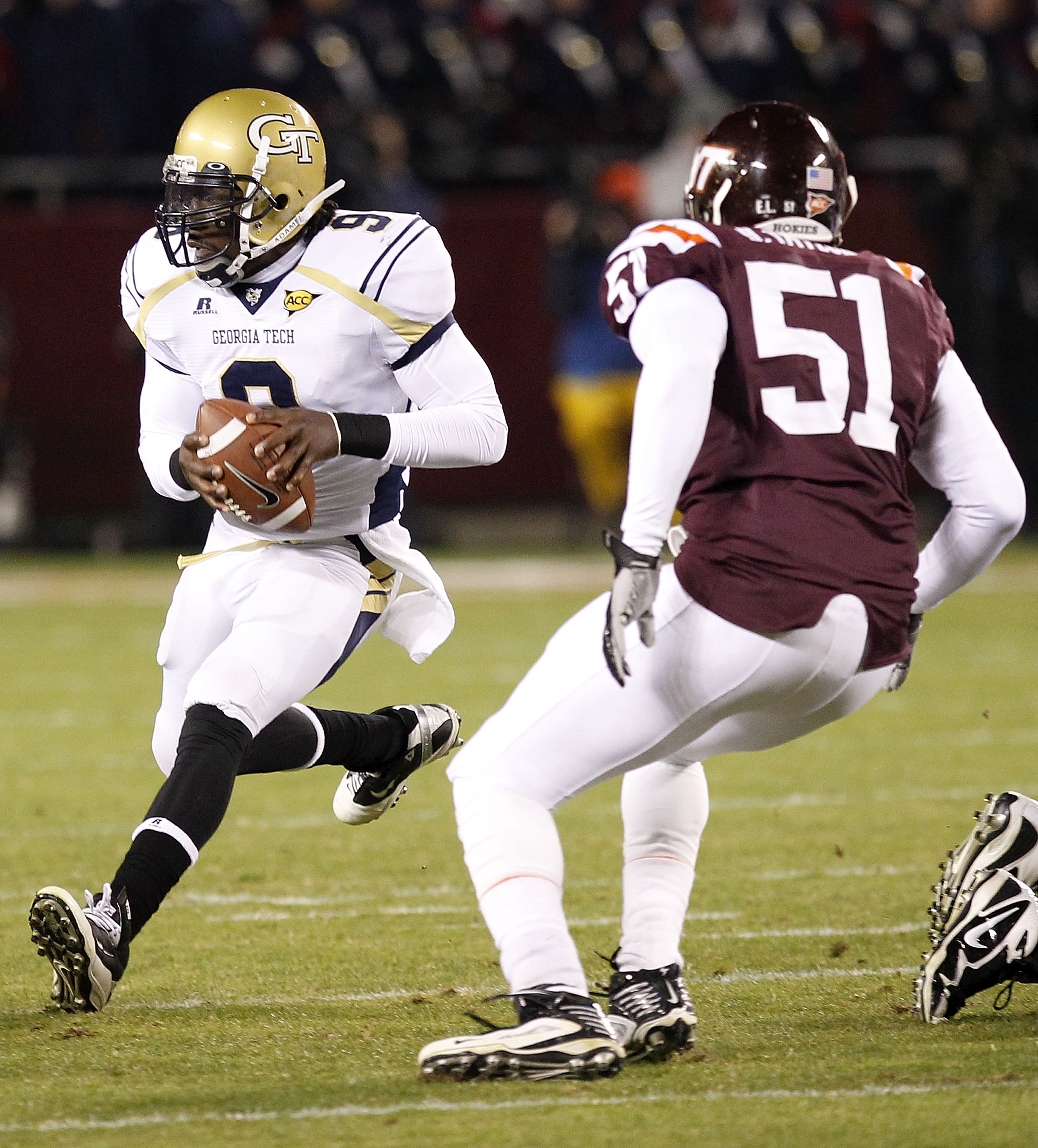 BLACKSBURG, VA - NOVEMBER 04: Quarterback Joshua Nesbitt #9 of the Georgia Tech Yellow Jackets runs with the ball as linebacker Bruce Taylor #51 of the Virginia Tech Hokies chases at Lane Stadium on November 4, 2010 in Blacksburg, Virginia.  (Photo by Geo