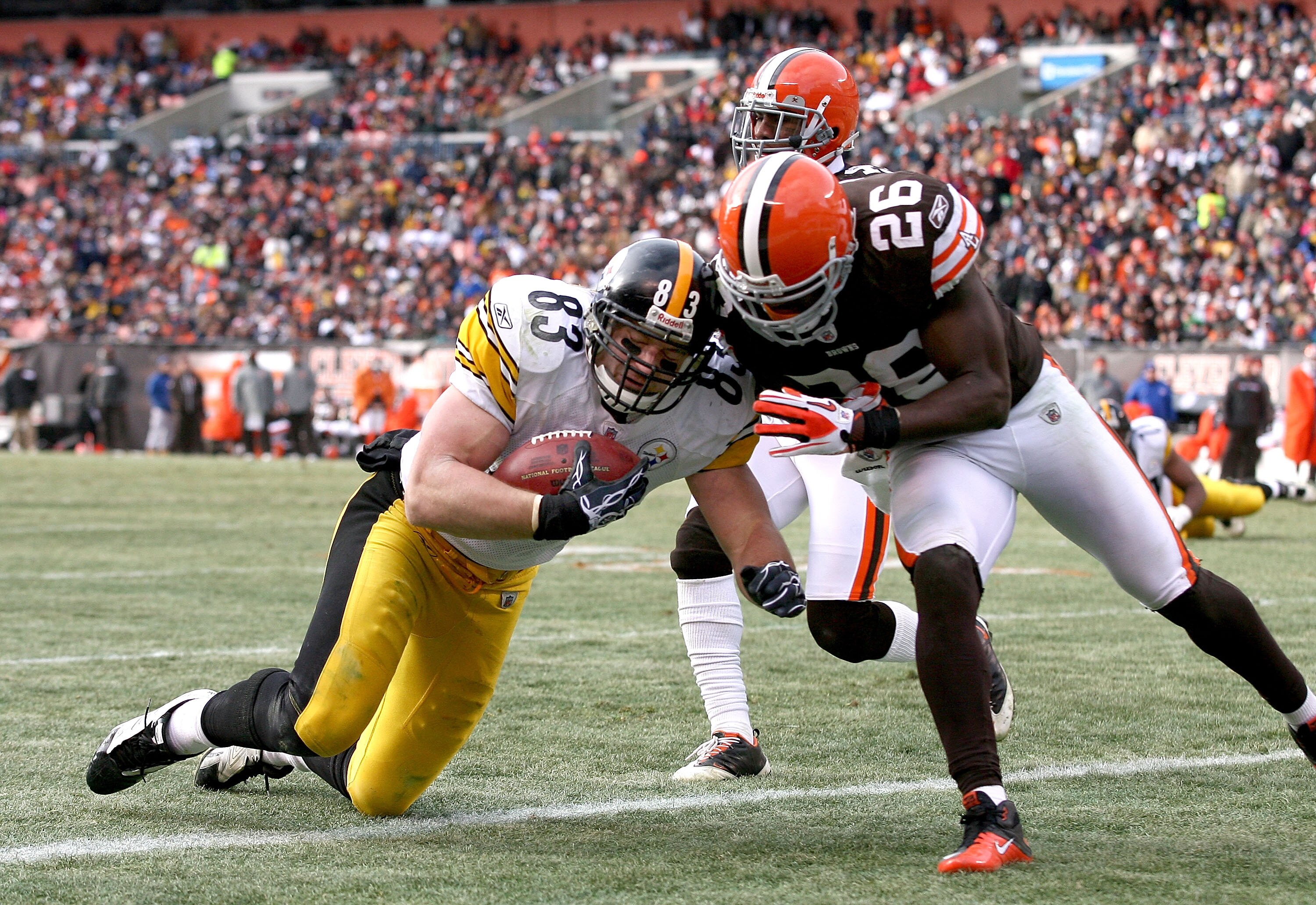 CLEVELAND, OH - JANUARY 02:  Tight end Heath Miller #83 of the Pittsburgh Steelers scores a touchdown as he is hit by defensive back Abram Elam #26 of the Cleveland Browns at Cleveland Browns Stadium on January 2, 2011 in Cleveland, Ohio.  (Photo by Matt