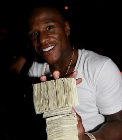 Mayweather holds a gigantic stack of money.