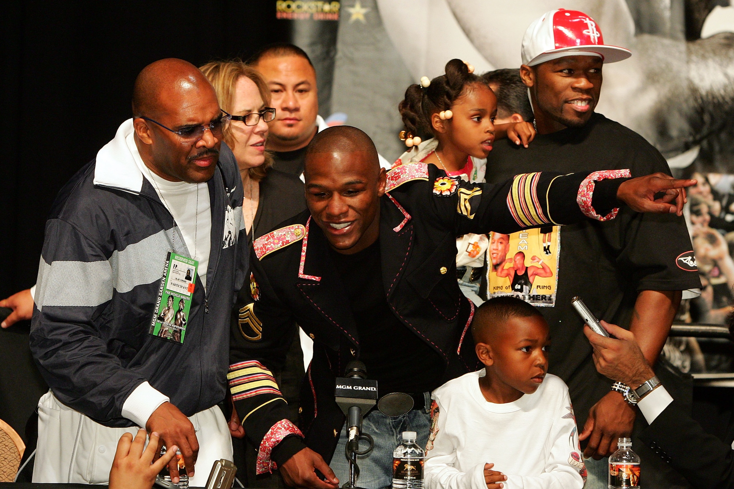 LAS VEGAS - MAY 05:  Floyd Mayweather Jr. speaks to the press as his manager Leonard Ellerbe (L) looks on while rapper 50 Cent holds Mayweather's daughter Iyanna behind Mayweather's son Koraun during the post-fight news conference after Mayweather defeate