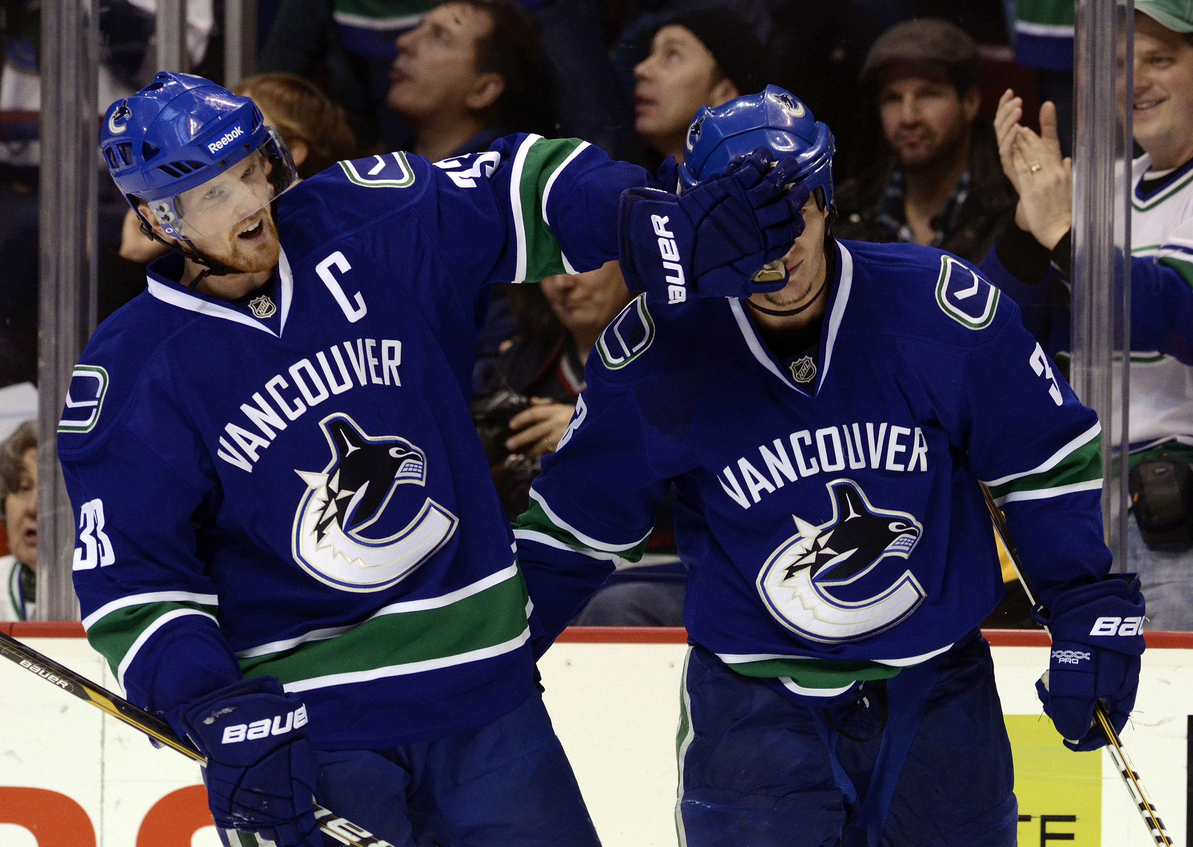 VANCOUVER, CANADA - DECEMBER 26: Kevin Bieksa #3 of the Vancouver Canucks is gets a friendly face wash from Henrik Sedin #33 after scoring what proved to be the game winning goal in a 3-2 win against the Edmonton Oilers during the third period in NHL acti