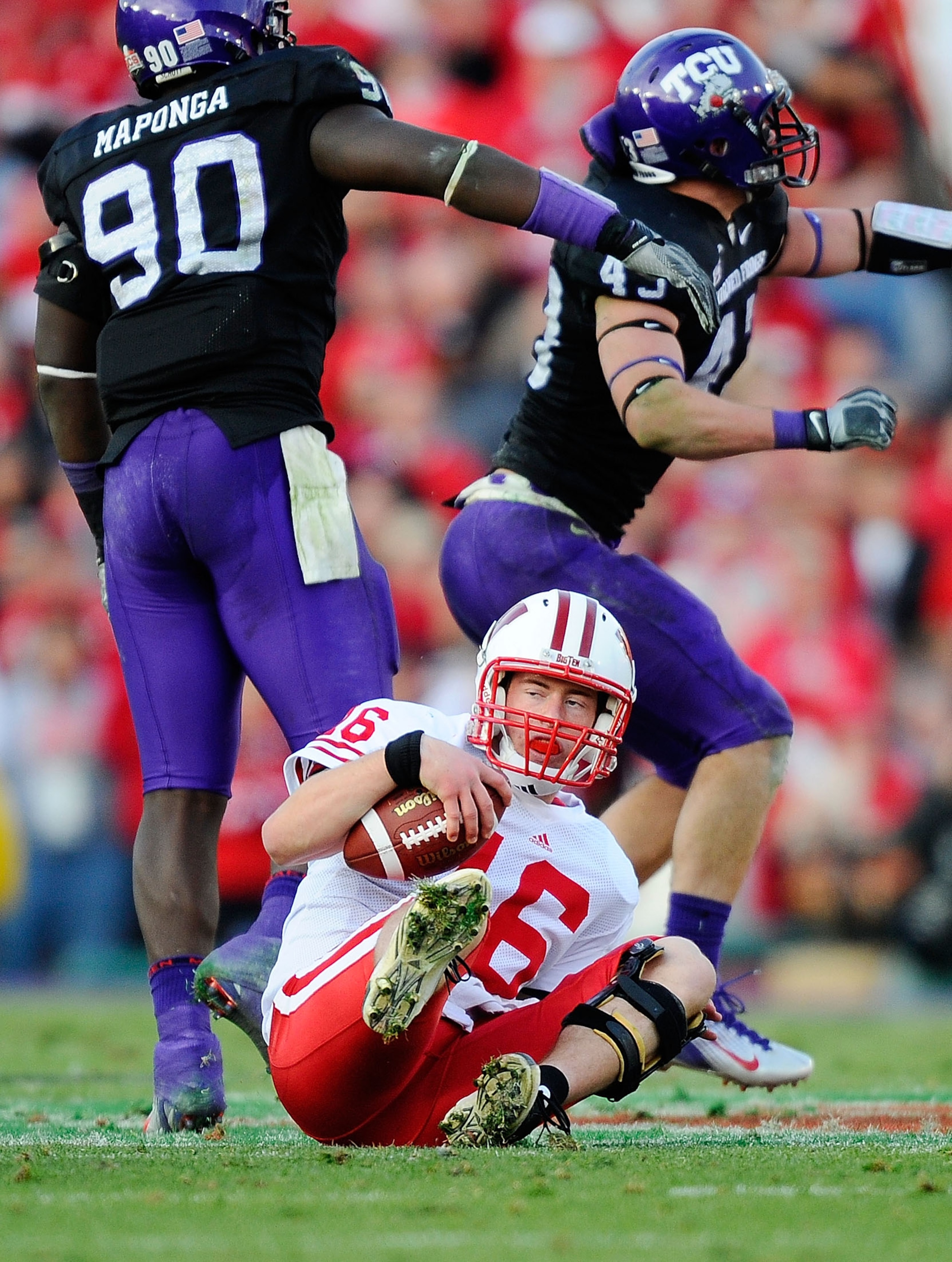PASADENA, CA - JANUARY 01:  Quarterback Scott Tolzien #16 of the Wisconsin Badgers sits on the ground after being sacked by linebacker Tank Carder #43 of the TCU Horned Frogs during the 97th Rose Bowl game on January 1, 2011 in Pasadena, California.  (Pho