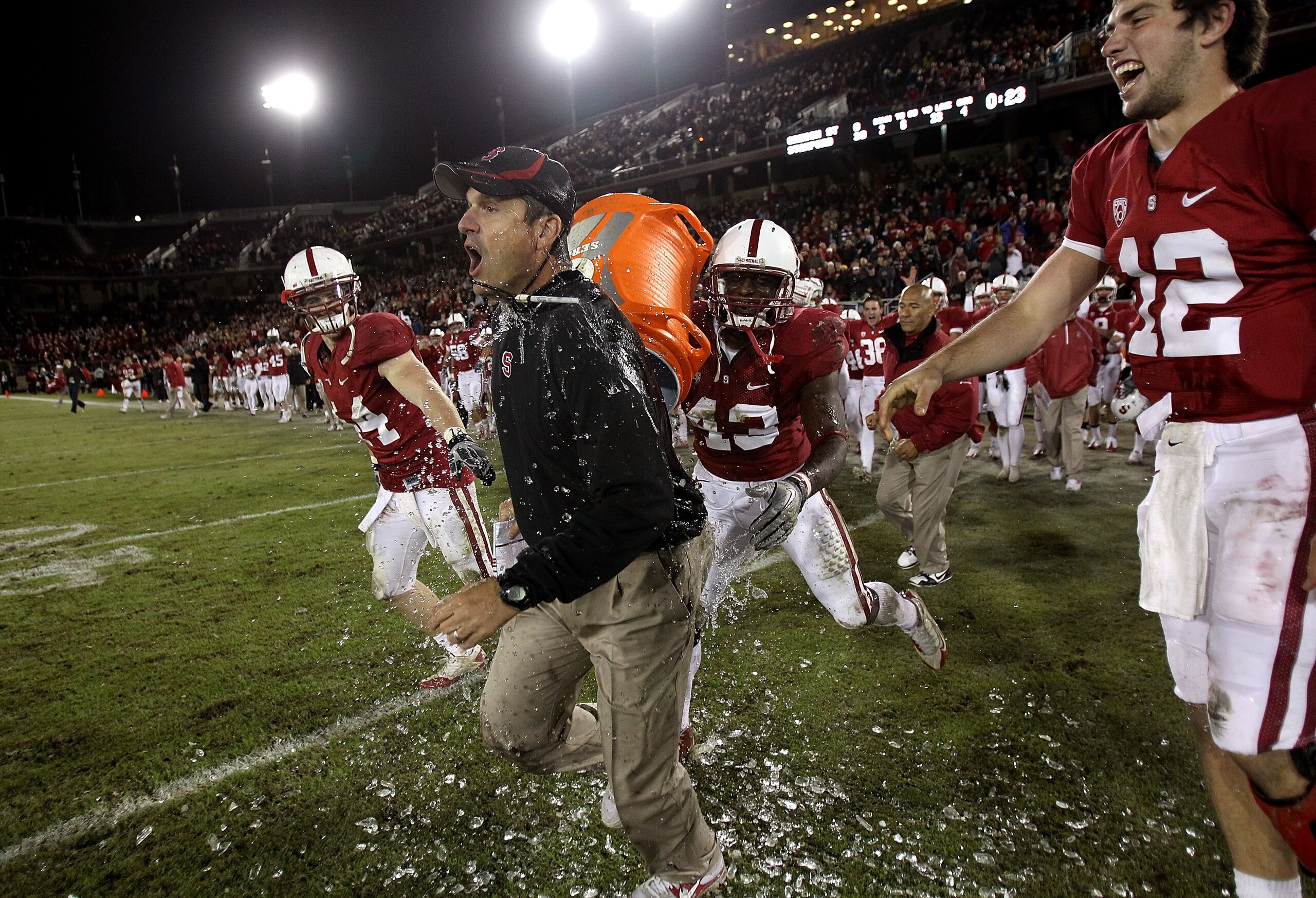 PALO ALTO, CA - NOVEMBER 27:  Head coach Jim Harbaugh of the Stanford Cardinal is covered with water from a Gatorade cooler by Andrew Luck #12 and Chike Amajoyi #43 after the Cardinal beat the Oregon State Beavers at Stanford Stadium on November 27, 2010