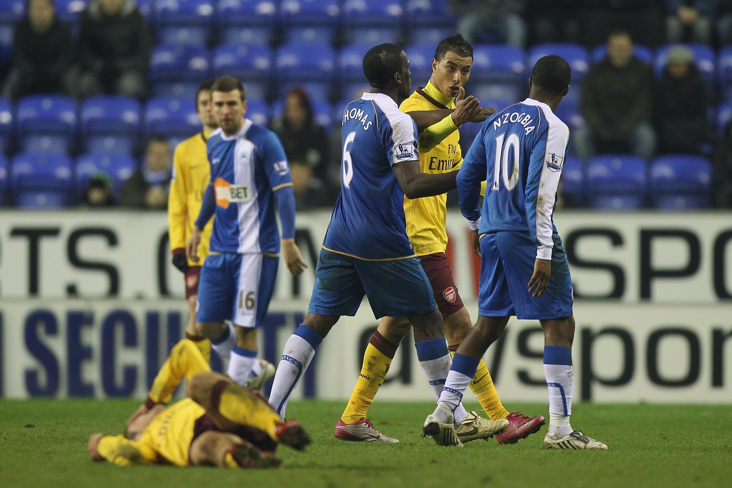 WIGAN, ENGLAND - DECEMBER 29: Marouane Chamakh (2R) of Arsenal confronts Charles N'Zogbia (R) of Wigan Athletic after head butting Jack Wilshire (grounded l) and is sent off by referee Lee Probert during the Barclays Premier League match between Wigan Ath