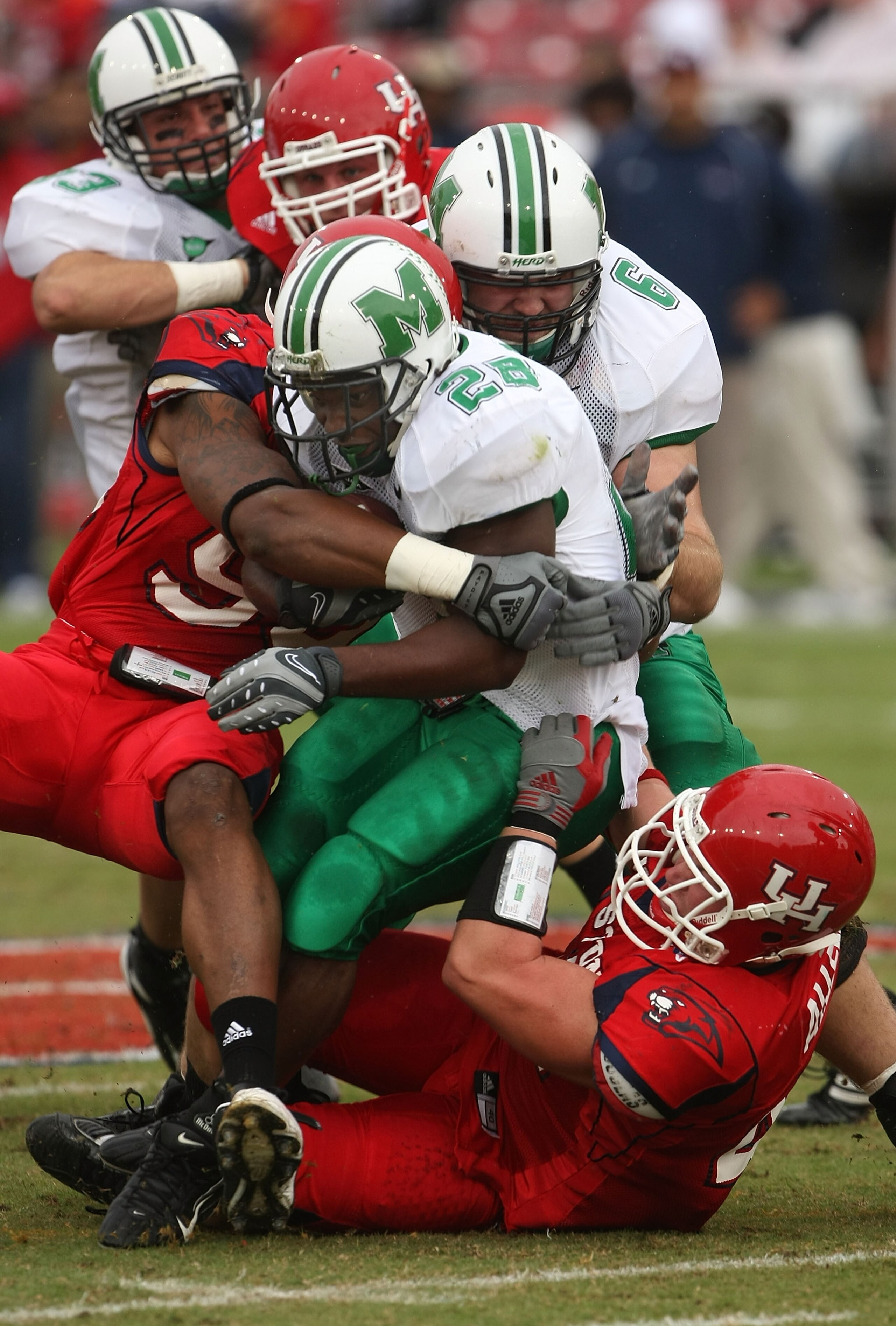 HOUSTON - NOVEMBER 17: Running back Chubb Small #28 of the Marshall Thundering Herd is tackled by defensive lineman Ell Ash #90 and linebacker Trent Allen #41 of the Houston Cougars at Robertson Stadium November 17, 2007 in Houston, Texas. Houston won 35 HOUSTON - NOVEMBER 17: Running back Chubb Small #28 of the Marshall Thundering Herd is tackled by defensive lineman Ell Ash #90 and linebacker Trent Allen #41 of the Houston Cougars at Robertson Stadium November 17, 2007 in Houston, Texas. Houston won 35