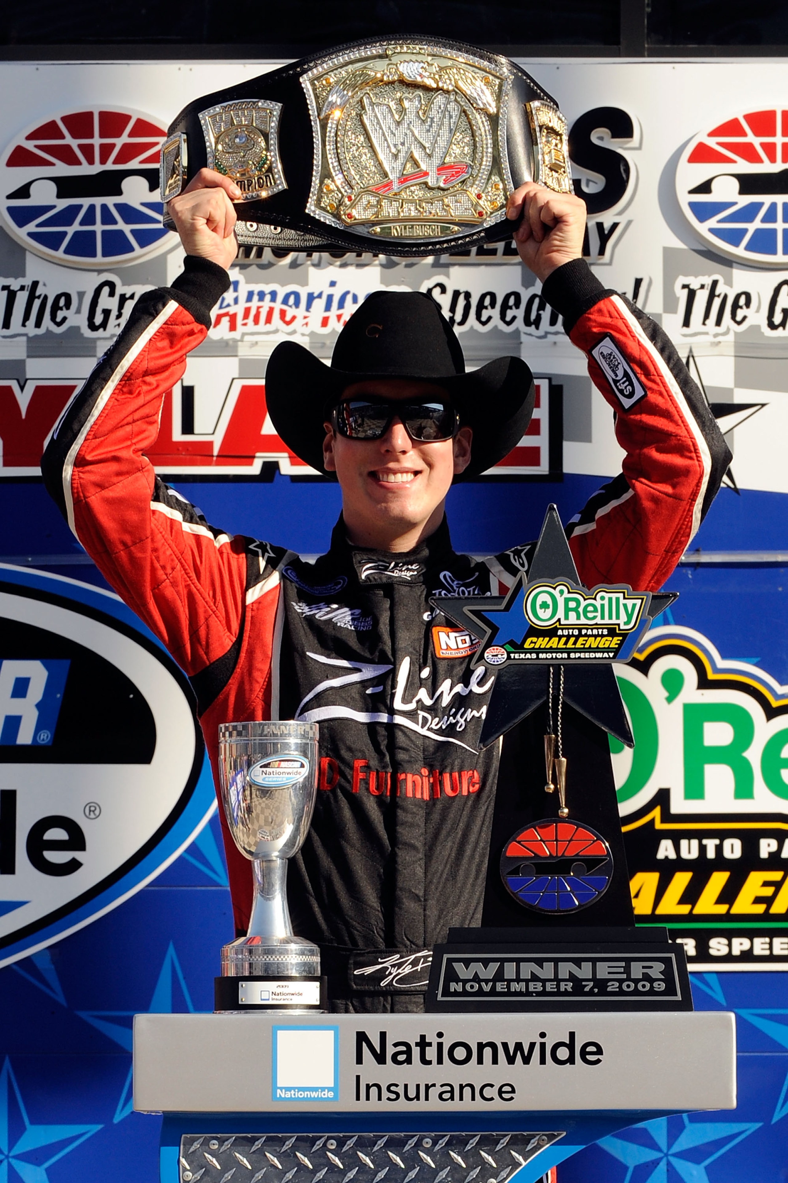 FORT WORTH, TX - NOVEMBER 07: Kyle Busch, driver of the #18 Z-Line Designs/WWE Smackdown Toyota, hoist a replica of the WWE world championship belt on victory lane after winning the NASCAR Nationwide Series O'Reilly Challenge at Texas Motor Speedway on FORT WORTH, TX - NOVEMBER 07: Kyle Busch, driver of the #18 Z-Line Designs/WWE Smackdown Toyota, hoist a replica of the WWE world championship belt on victory lane after winning the NASCAR Nationwide Series O'Reilly Challenge at Texas Motor Speedway on