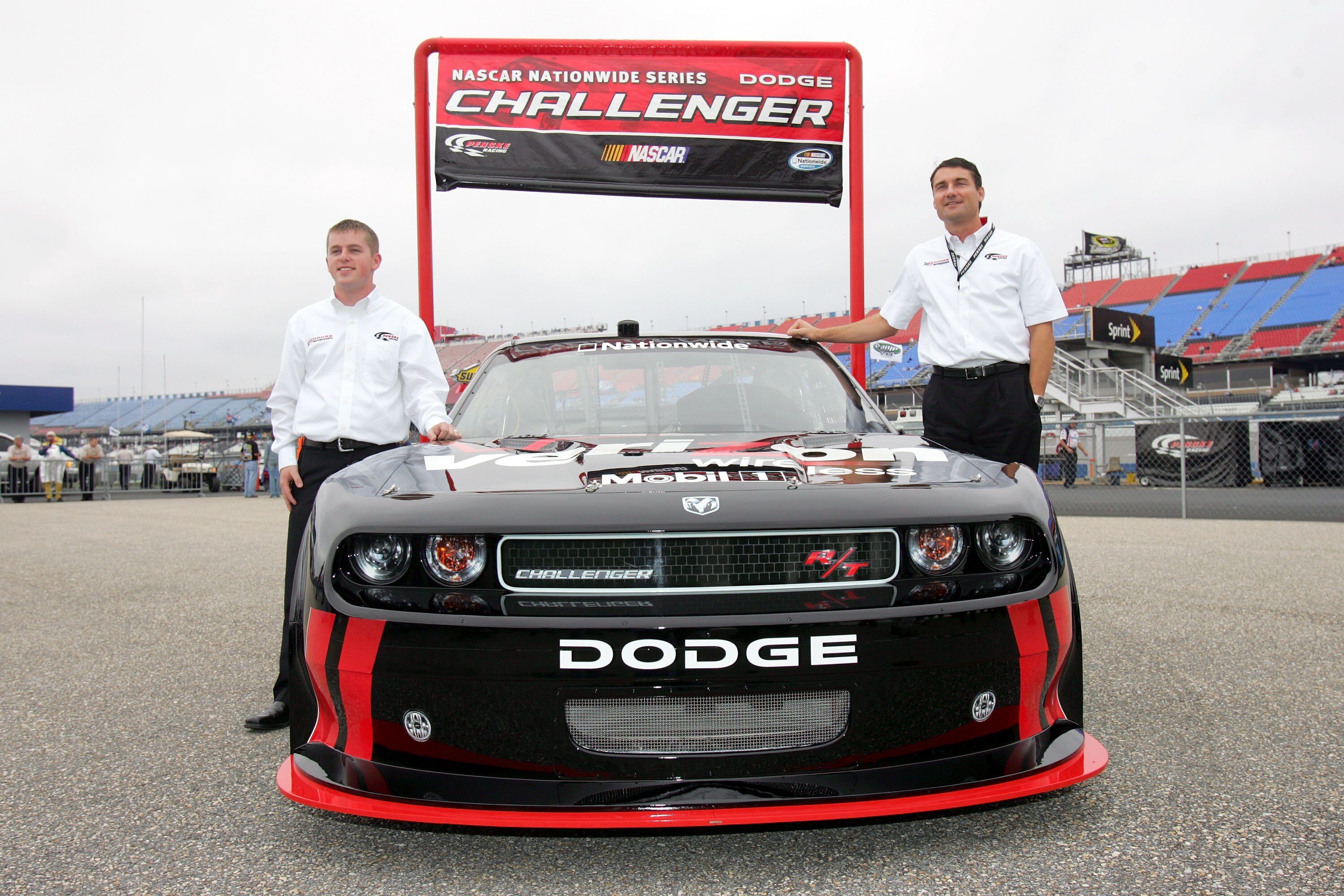 TALLADEGA, AL - OCTOBER 30:  Nationwide series Justin Allgaier (L), driver of the #12 Verizon Wireless Dodge, and Tim Cindric, President of Penske Racing, pose in the garage area after practice for the NASCAR Sprint Cup Series AMP Energy 500 at Talladega