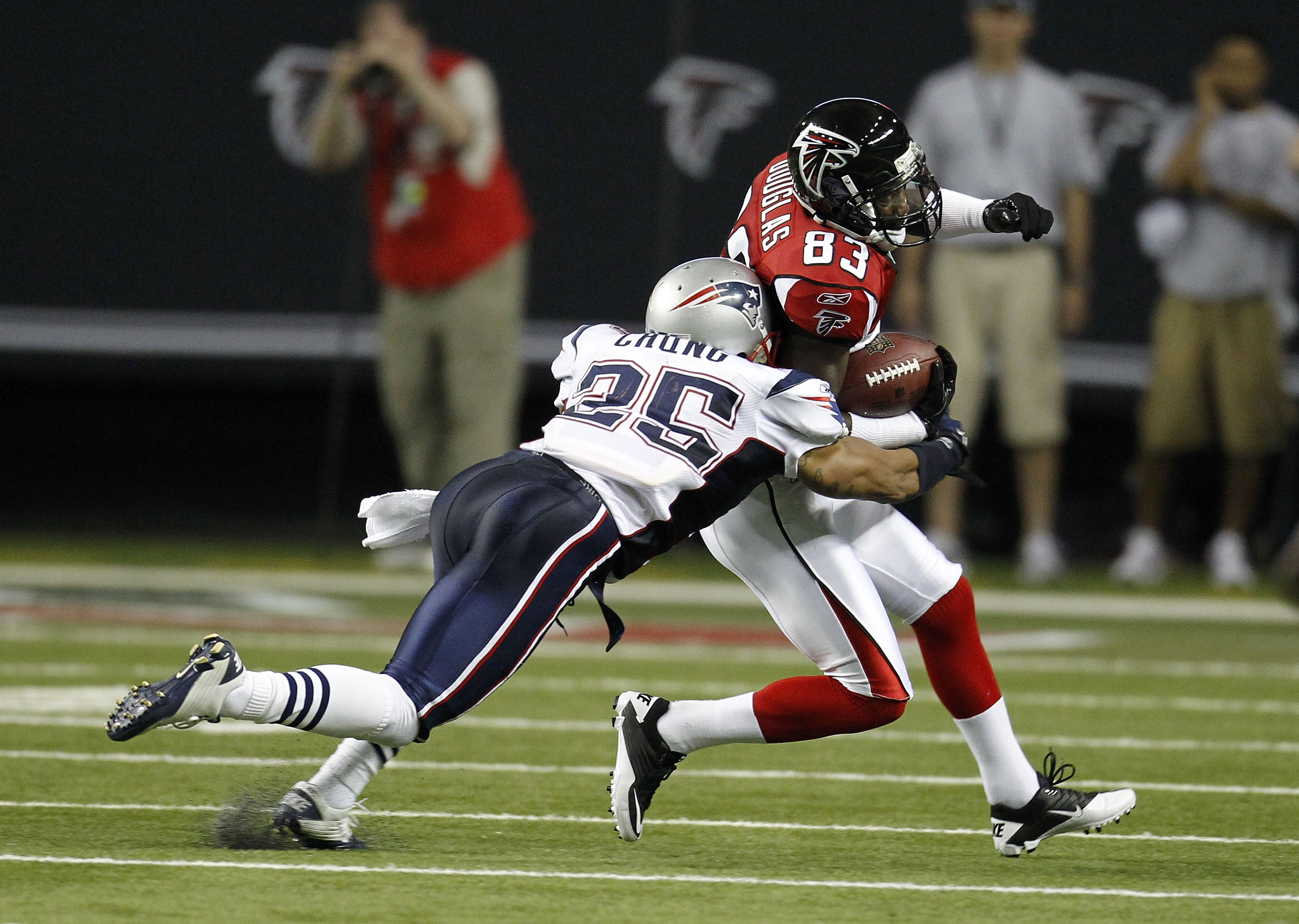 ATLANTA - AUGUST 19:  Wide receiver Harry Douglas #83 of the Atlanta Falcons is tackled by safety Patrick Chung #25 of the New England Patriots during the preseason game at the Georgia Dome on August 19, 2010 in Atlanta, Georgia.  (Photo by Mike Zarrilli/