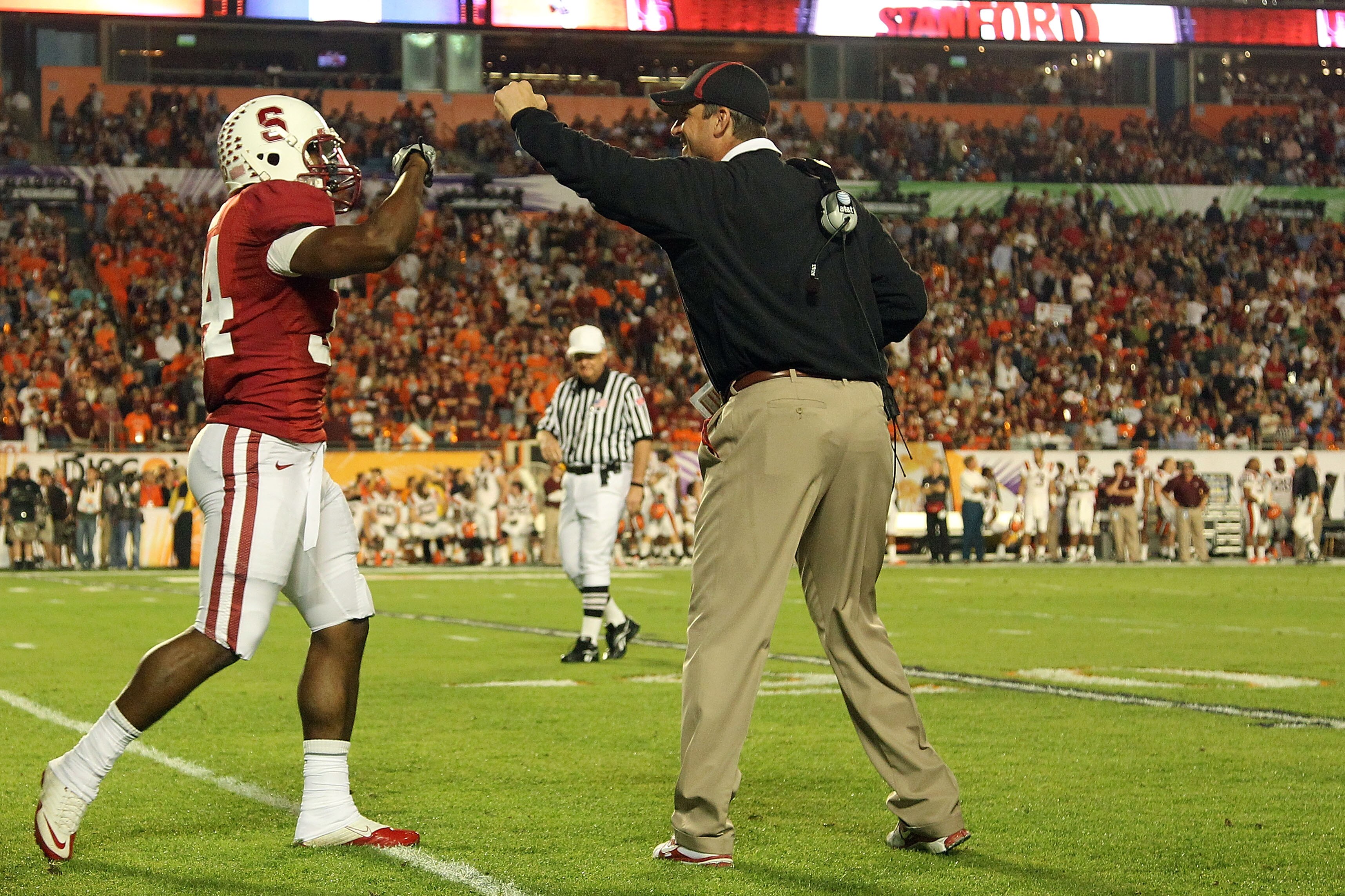 MIAMI, FL - JANUARY 03:  Head coach Jim Harbaugh of the Stanford Cardinal congratulates Jeremy Stewart #34 after Stewart scored a 60-yard rushing touchdown in the first quarter against the Virginai Tech Hokies during the 2011 Discover Orange Bowl at Sun L