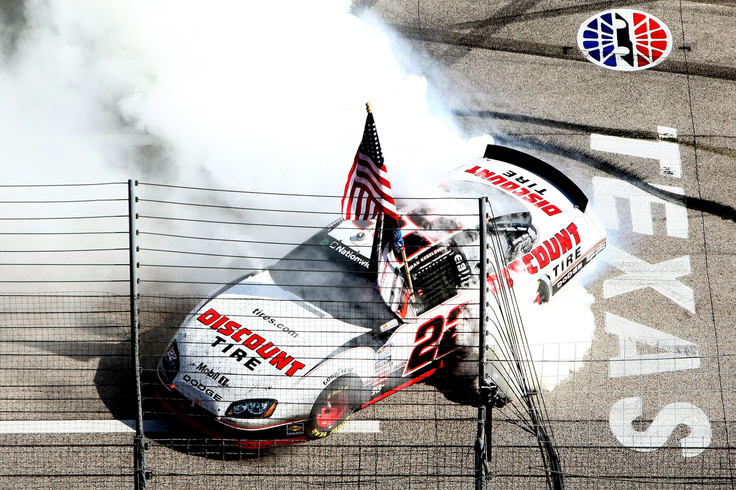 FORT WORTH, TX - NOVEMBER 06:  Brad Keselowski, driver of the #22 Discount Tire Dodge, celebrates with a burnout after winning the Nationwide championship with a third-place finish in the NASCAR Nationwide Series O'Reilly Auto Parts Challenge at Texas Mot