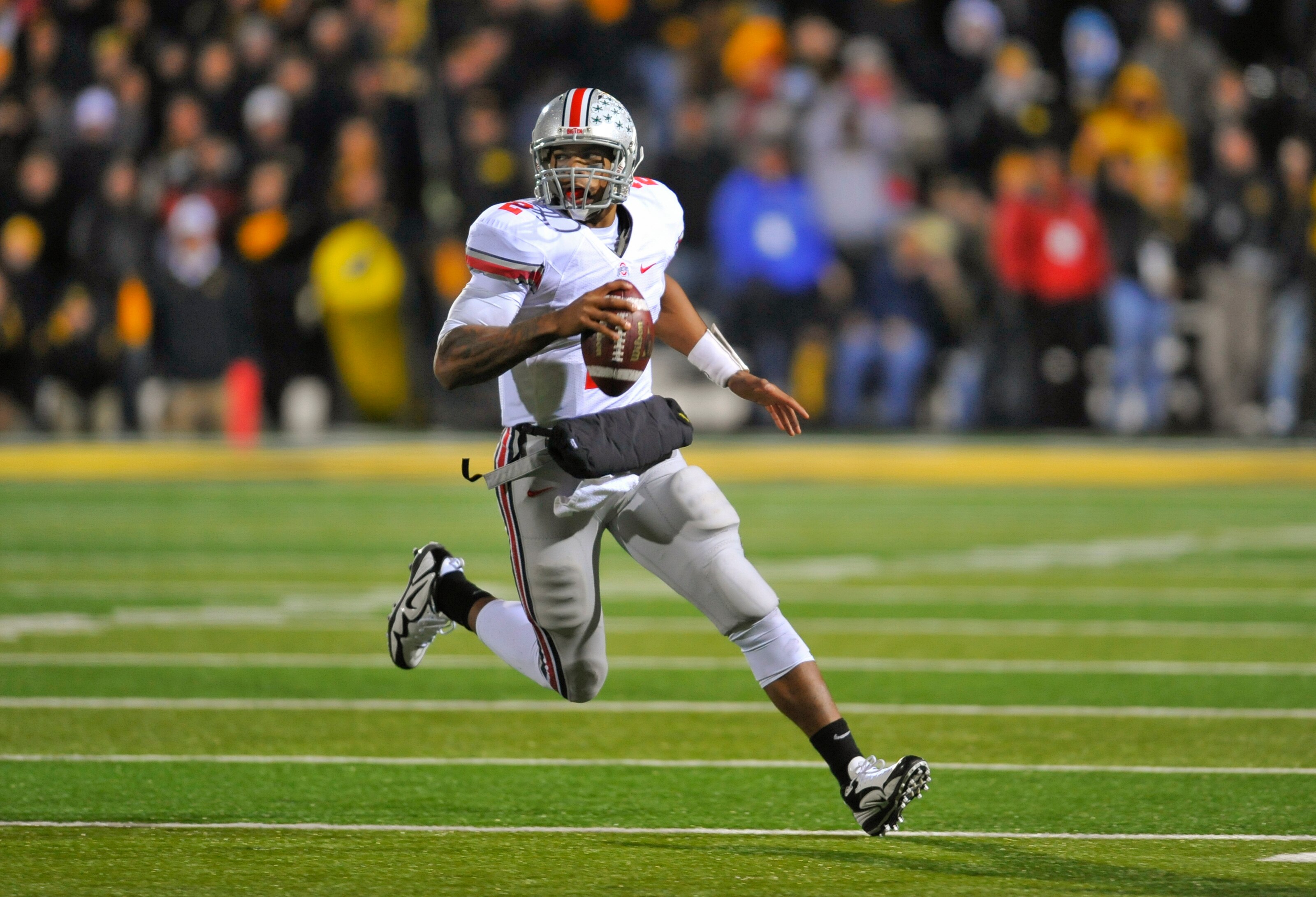 IOWA CITY, IA - NOVEMBER 20:  Quarterback Terrelle Pryor #2 of the Ohio State Buckeyes scrambles for yards under pressure from University of Iowa Hawkeyes defenders during the second half of play at Kinnick Stadium on November 20, 2010 in Iowa City, Iowa.