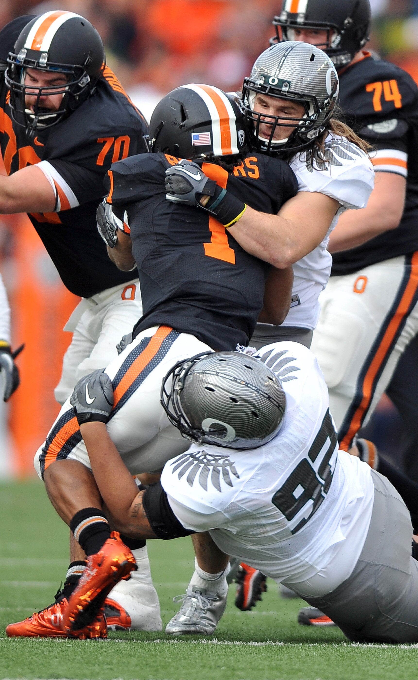 CORVALLIS, OR - DECEMBER 4: Jacquizz Rodgers #1 of the Oregon State Beavers is wrapped up by Casey Matthews #55 and Wade Keliikipi #92 of the Oregon Ducks in the first quarter of the game at Reser Stadium on December 4, 2010 in Corvallis, Oregon. (Photo b